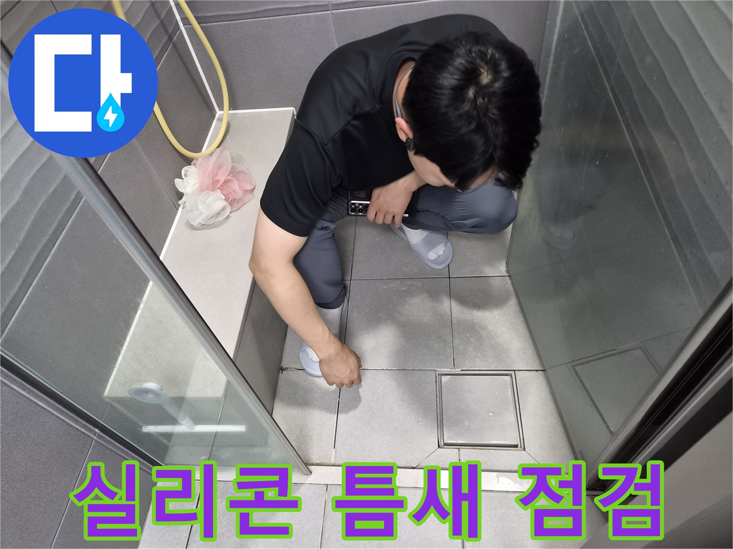 강동구 천호동 샤워실에서-전문가가 유리 파티션 하단의-실리콘 마감재의 미세한 틈새를-꼼꼼히 점검하는 모습