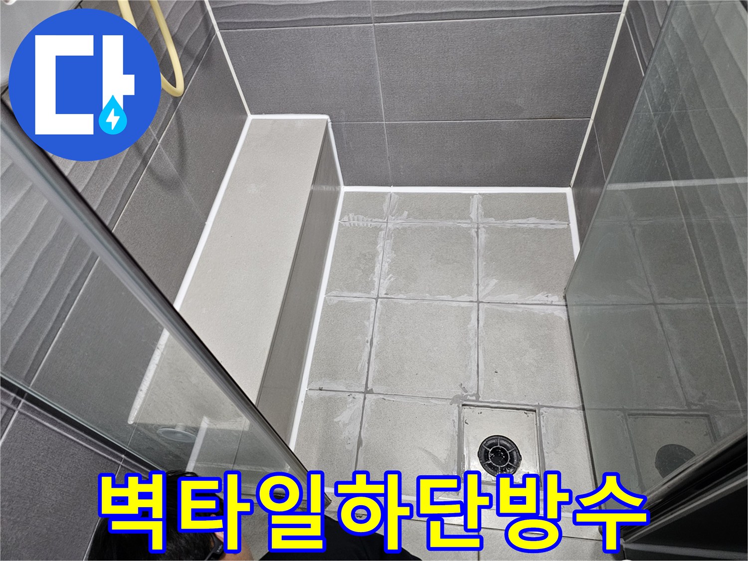 강동구 천호동 욕실의 벽 타일 하단과-바닥 경계의 오래된 실리콘을 제거하고-새로운 방수 실리콘으로 재시공하는 모습입니다.