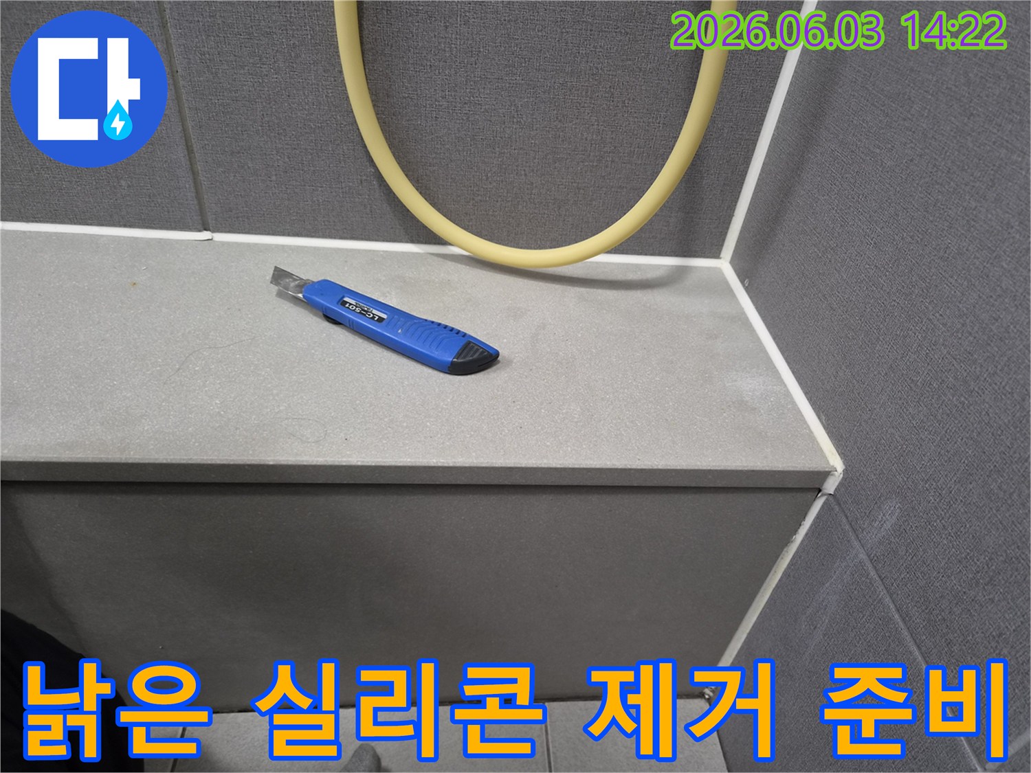 누수 보수 작업을 위해-커터칼이 놓여있는-욕실 타일 모서리 부분