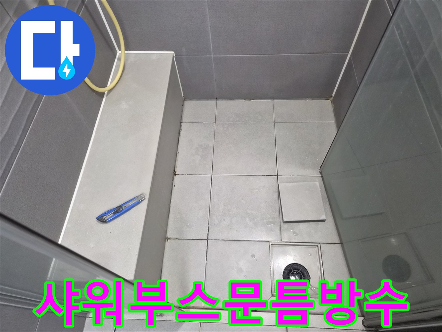 욕실-샤워-부스-문틈과-바닥-타일-그리고-배수구-주변을-점검하며-누수-방지를-위한-정밀-방수-시공을-준비하는-엔지니어의-작업-현장-사진입니다.