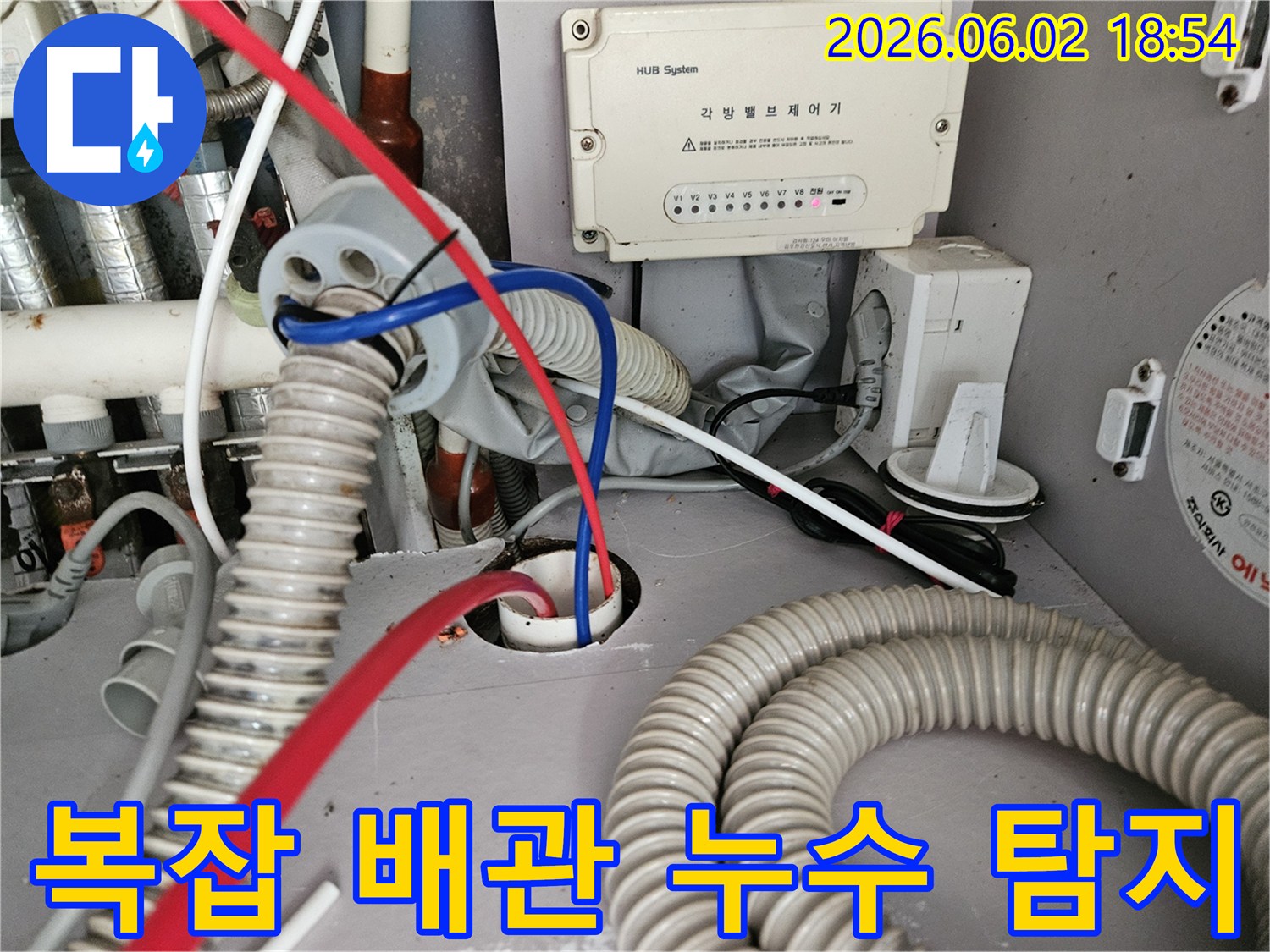 각종 배관과 전선이 복잡하게 얽힌 공간에서 누수 원인을 탐지하는 장면입니다.