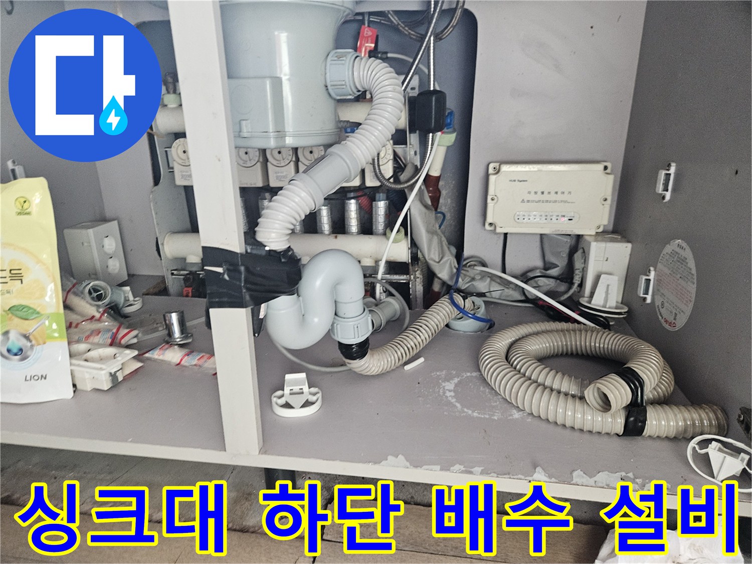 복잡하게 연결된-싱크대 하부 주름관과 배수 호스의 모습입니다.