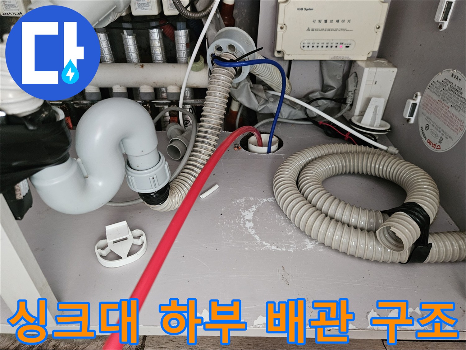 싱크대 하단 배수 호스와 연결된 배관 부위 사진