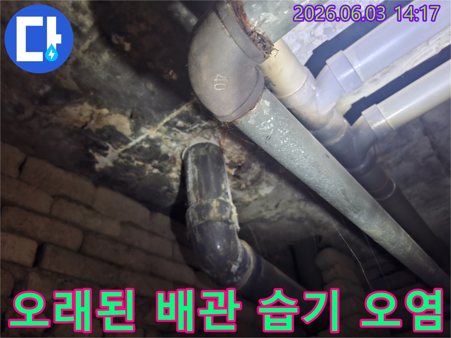 오래된 배관 주변에 만연한 습기와-그로 인한 오염을-누수 진단을 위해 촬영한 현장 사진