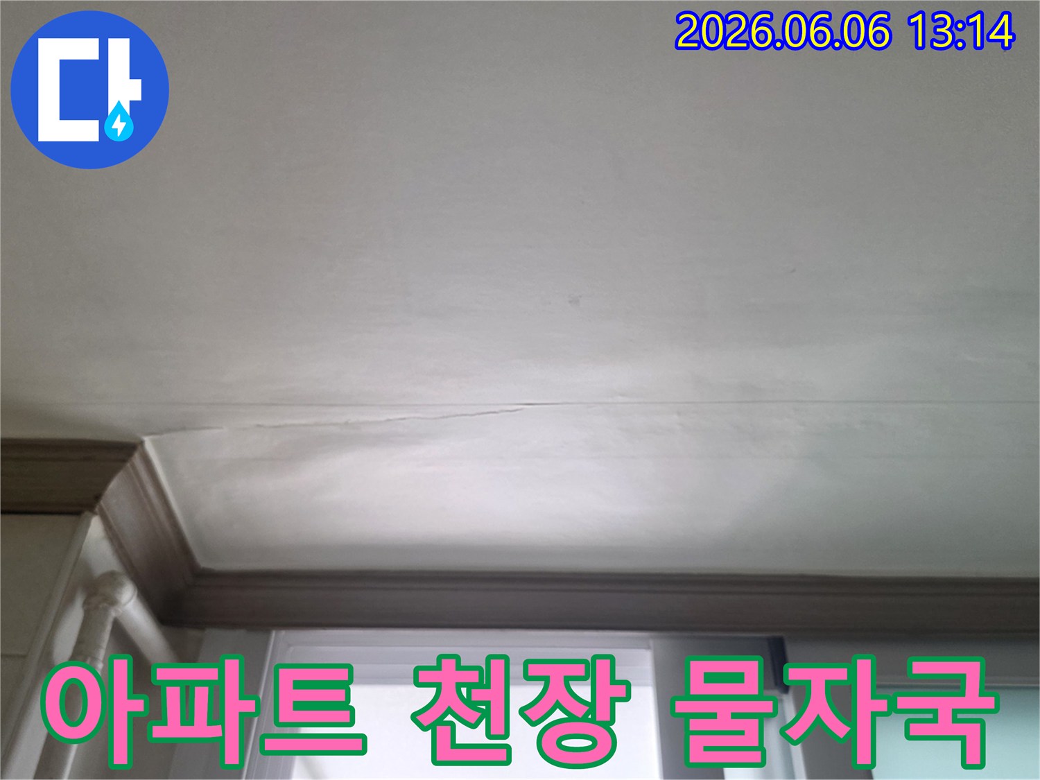 창문 위 천장에 물이 새어 얼룩진 아파트 벽면의 상세 사진