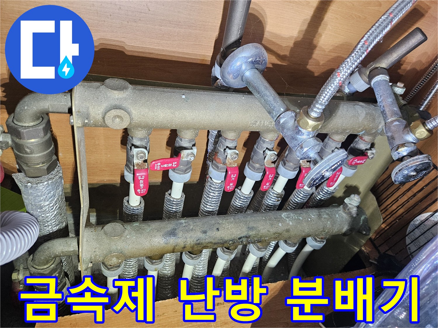 여러 개의 밸브가 달린 금속 분배기와 연결된 급수 배관들