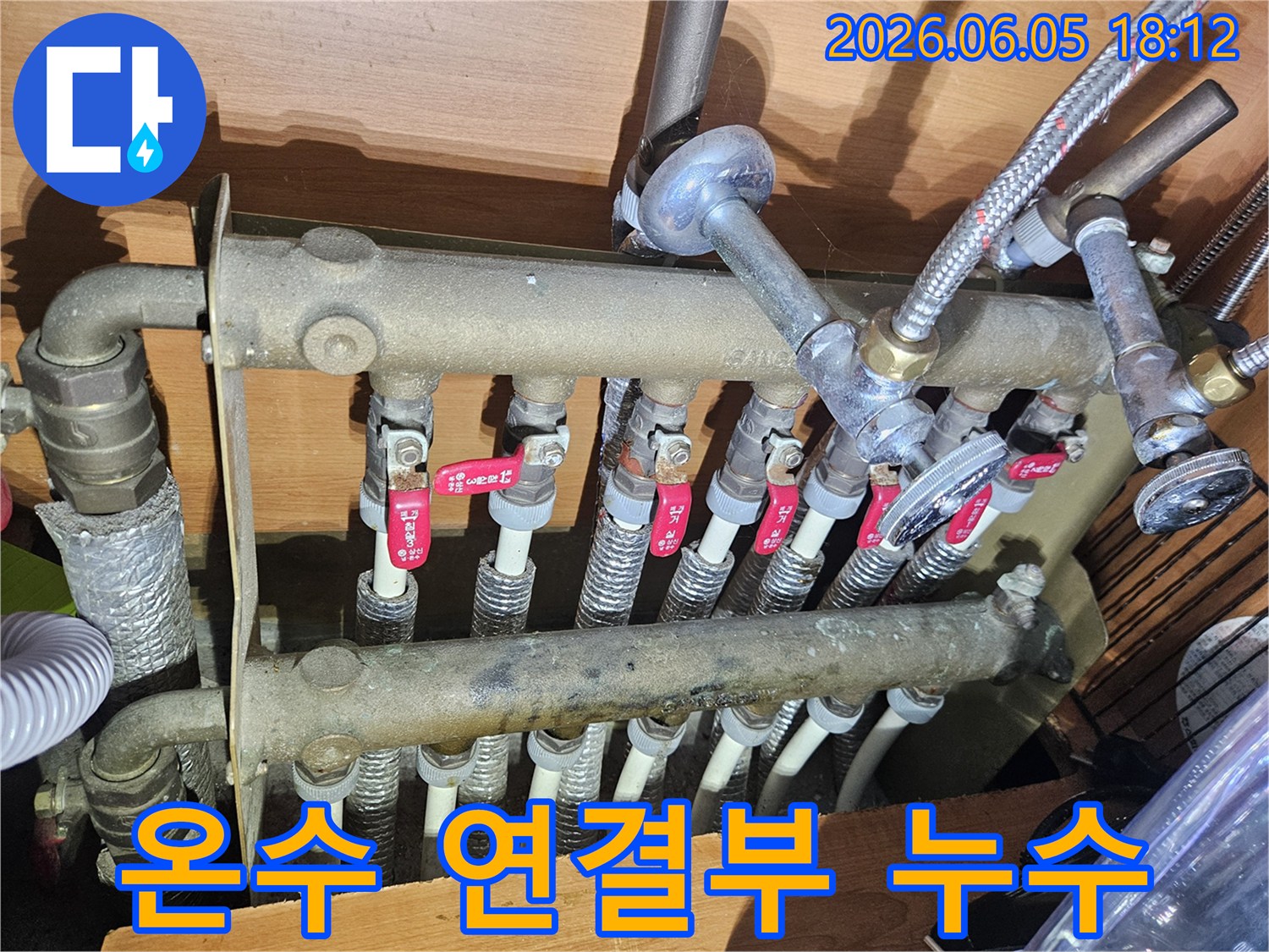 온수 분배기의 배관 연결 부위-누수 발생 여부를 확인하기 위해-전문가가 세밀하게 탐지하는 모습