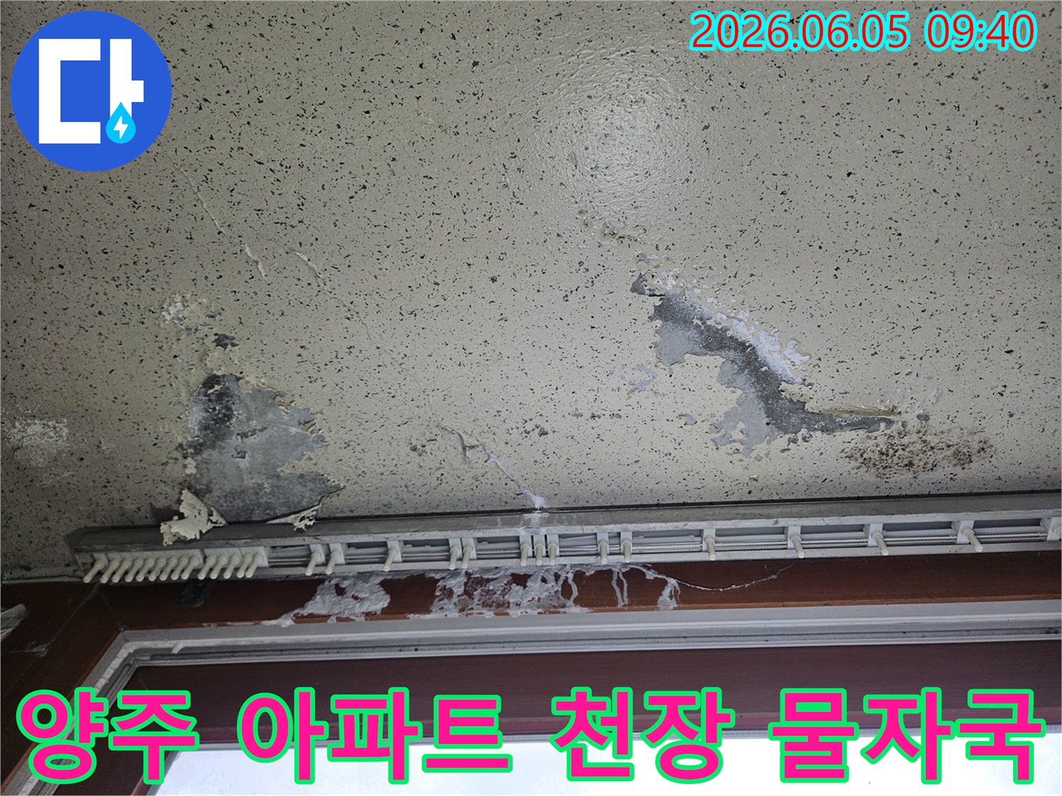 천장 중앙 부분에 물이 새어 페인트가 들뜨고-얼룩이 넓게 퍼진 모습으로-위층 누수 가능성을 시사합니다.