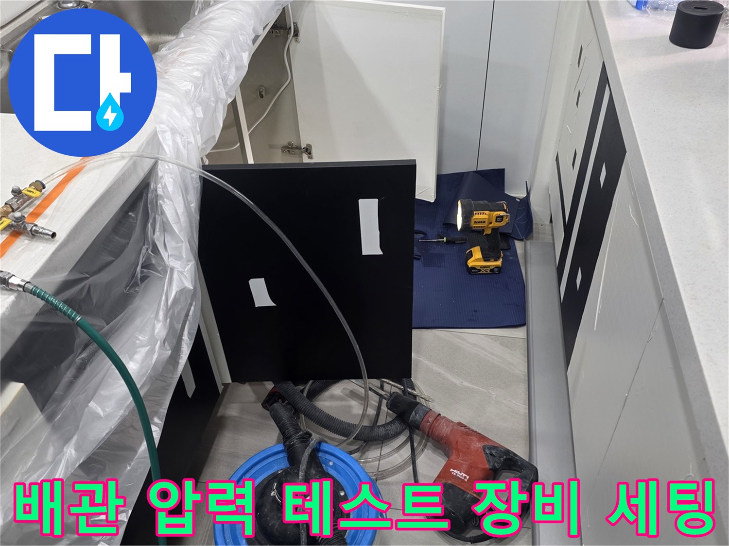 싱크대 아래 배관에 연결되어 압력을 표시하는 게이지와 호스
