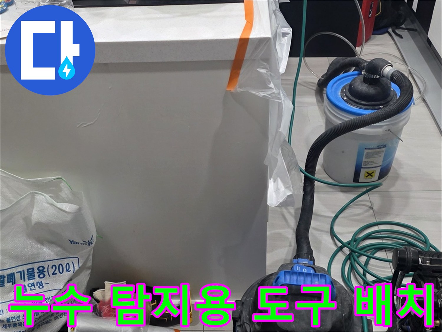 싱크대 하부 작업 공간에 준비된 누수 진단 및 청소 장비