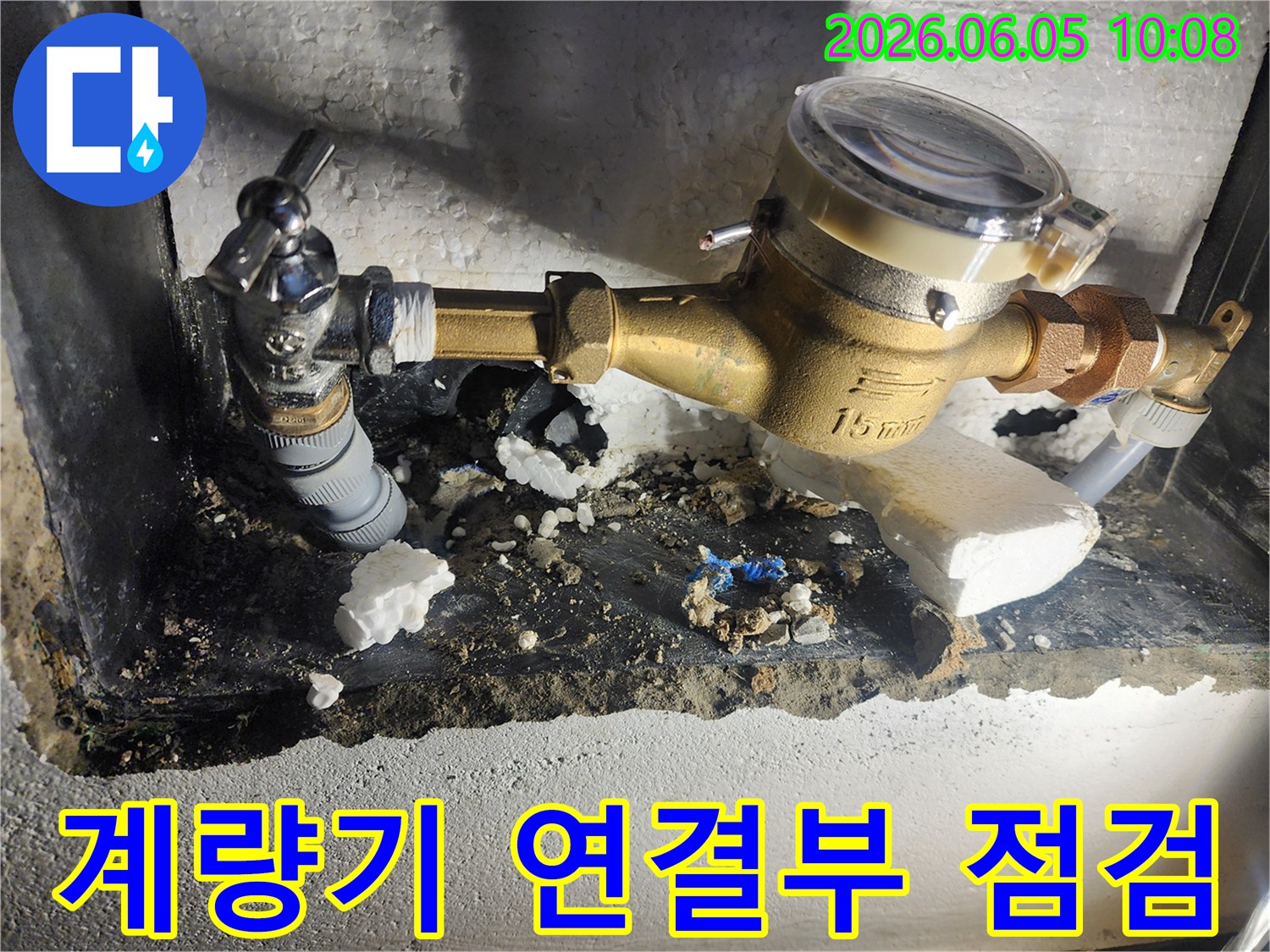 이 사진은 수도계량기 연결 부위에서 발생한 누수를 확인하기 위해-주변 배관의 상태를 꼼꼼하게 점검하는 모습을 보여줍니다-정확한 진단-배관 상태 확인