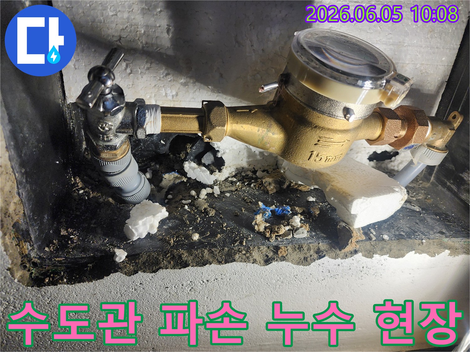 이 사진은 수도관 파손으로 인해 바닥이 젖고-주변 단열재가 손상된 누수 현장을 보여줍니다-정밀 탐지 후-배관 수리 작업을 진행하는 모습입니다