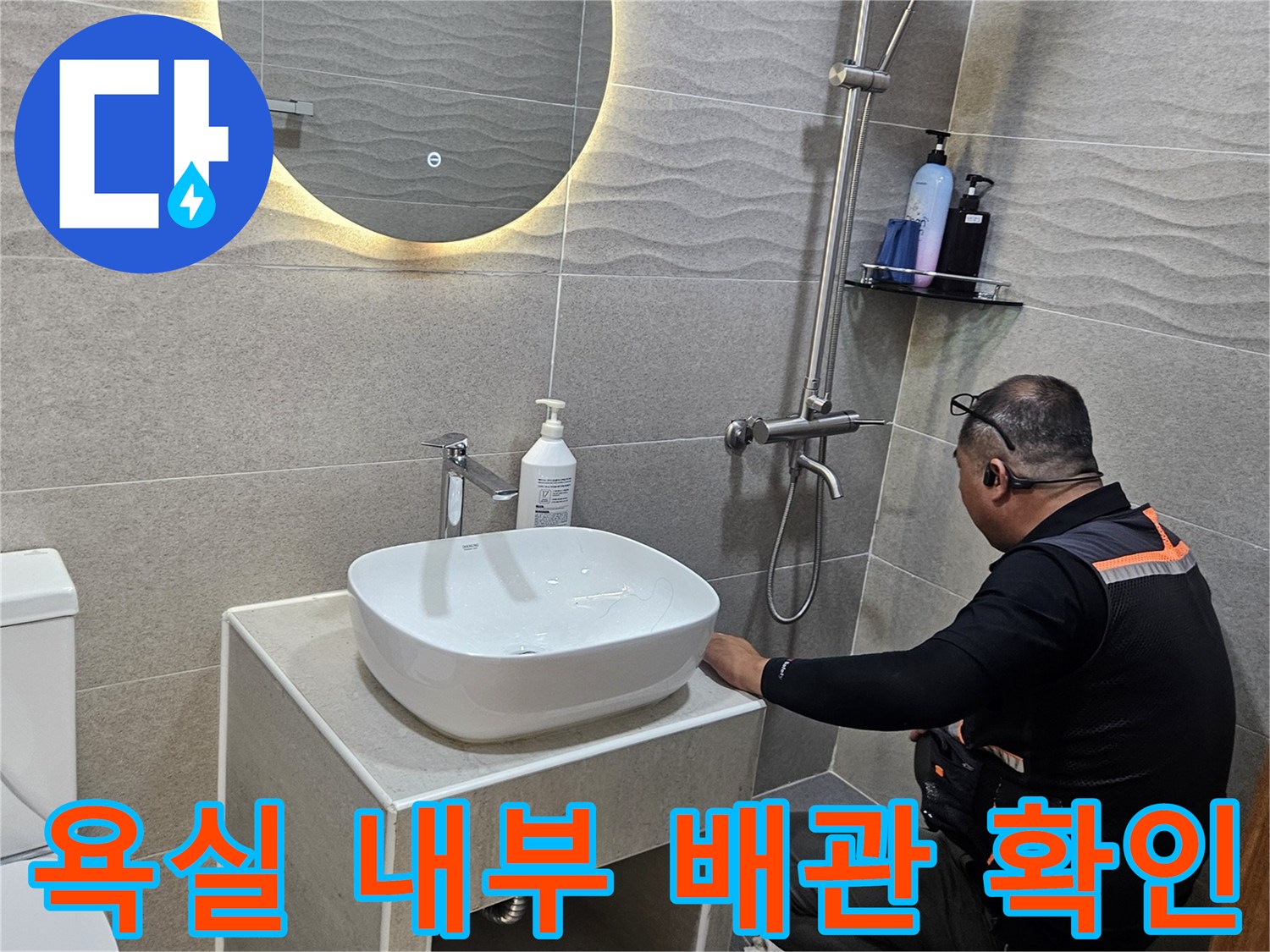 상면 현장-세면대 뒤쪽 타일 벽면의 누수 부위를 점검 중입니다