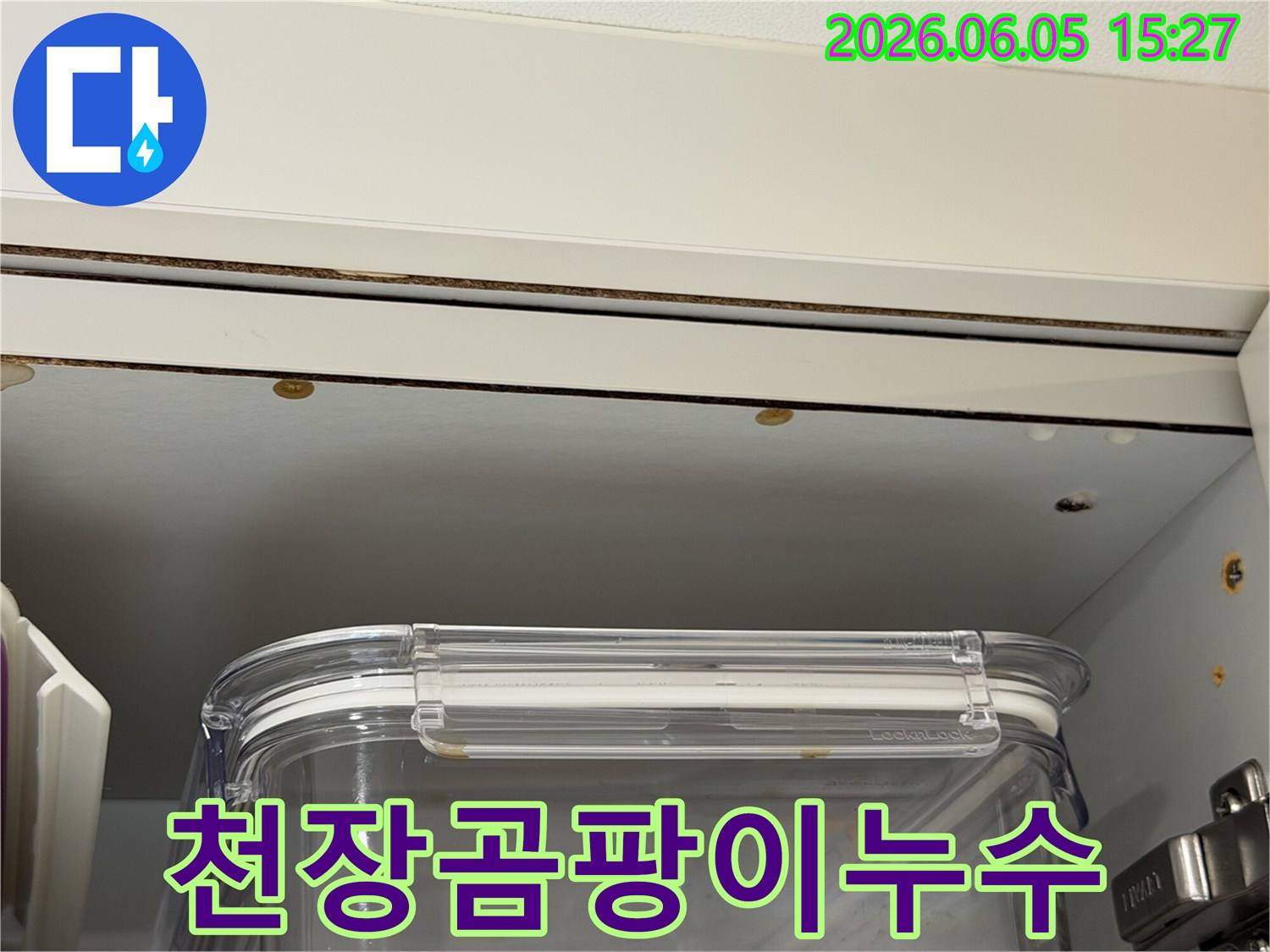 천장과 가구 사이-물기로 인해 생긴 곰팡이와 누수 흔적을 보여주는 근접 사진입니다.