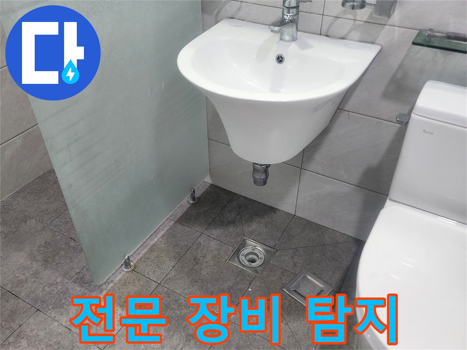 욕실 세면대-변기-바닥 배수구가-보이는-누수 현장에서-전문 장비를 활용한-정밀 탐지가-진행되고 있습니다