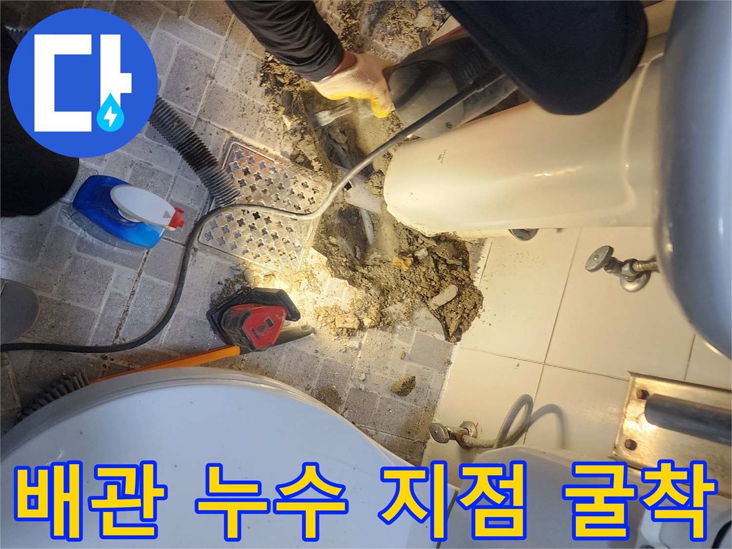 욕실 세면대 밑부분 타일을 제거하고 하부 배관의 누수 여부를 검사하는 장면입니다.