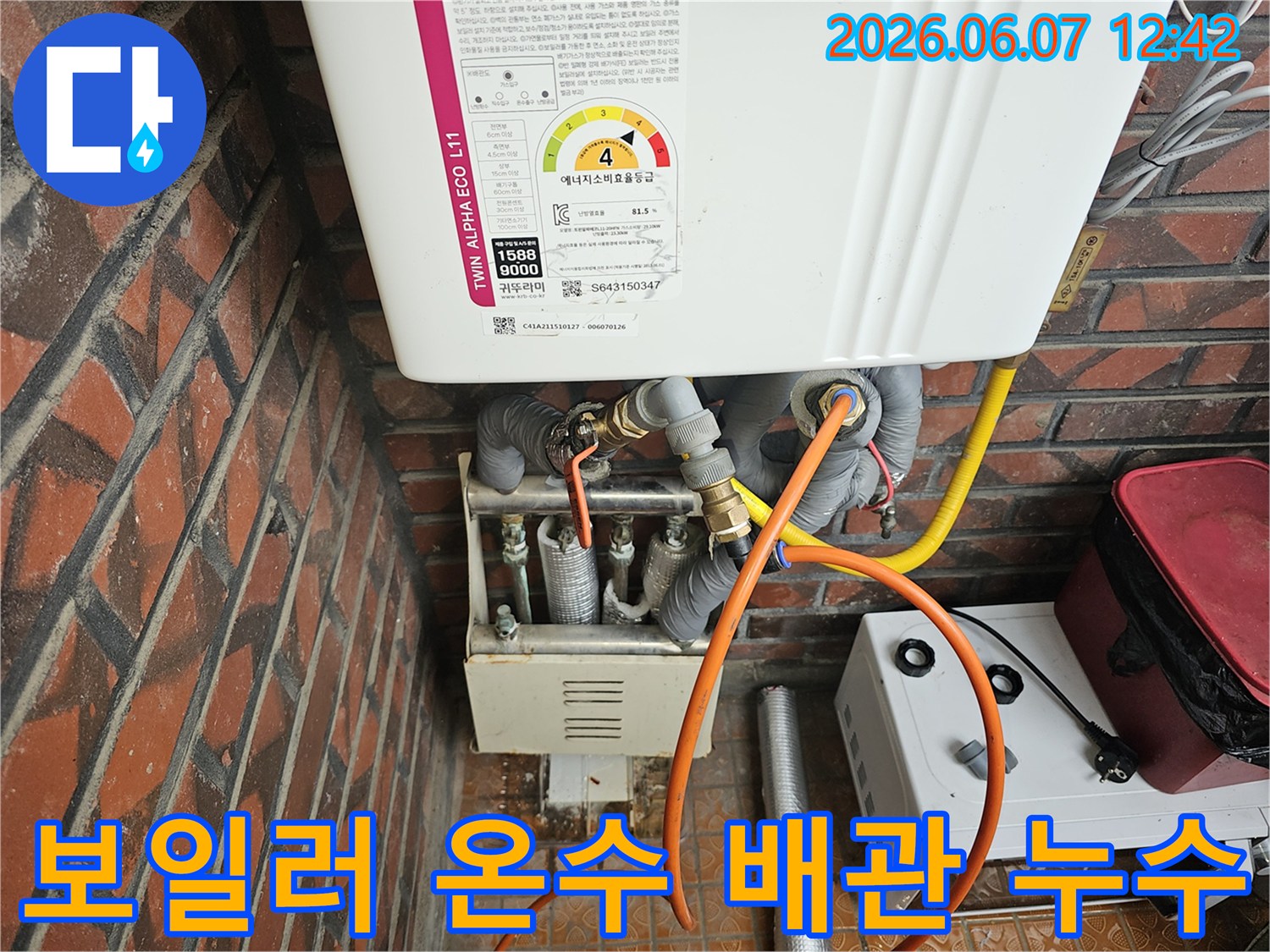 이 이미지는-서울 금천구 독산동의 한 건물에서-가스보일러의-온수 배관 연결 부위에서-발생한 누수를-엔지니어가-정밀하게 점검하는-모습을 담고 있습니다