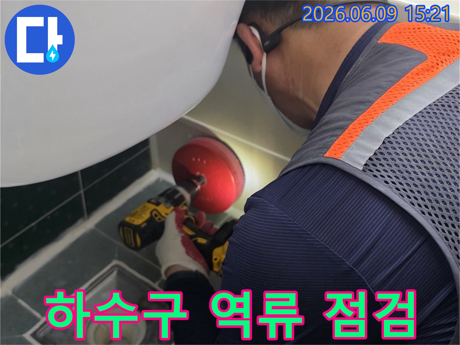안전-조끼를-입은-전문가가-욕실-배수구-근처에서-누수-원인을-찾기-위해-정밀-장비를-사용하여-작업하는-모습