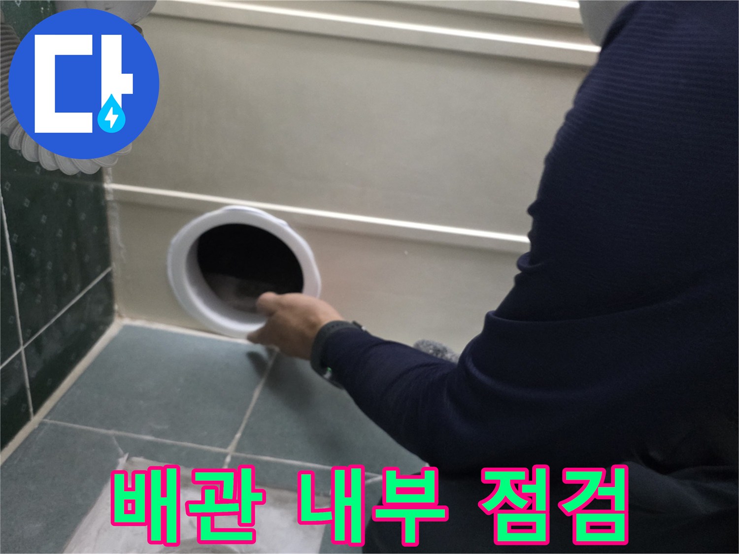 점검구-내부의-배관-연결부를-손으로-직접-살펴보는-작업자