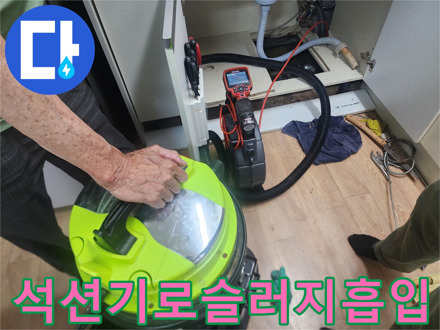 싱크대-아래쪽-배관에서-나온-이물질을-석션기로-흡입하는-모습