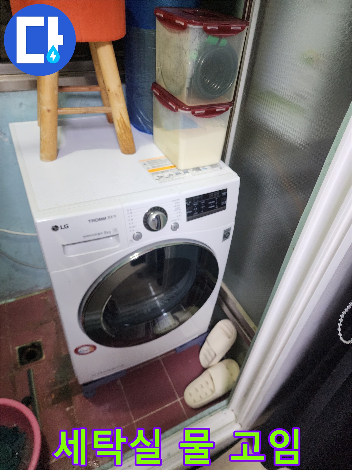 세탁기 아래쪽 배수구 주변에 물이 고여 있는 현장 사진