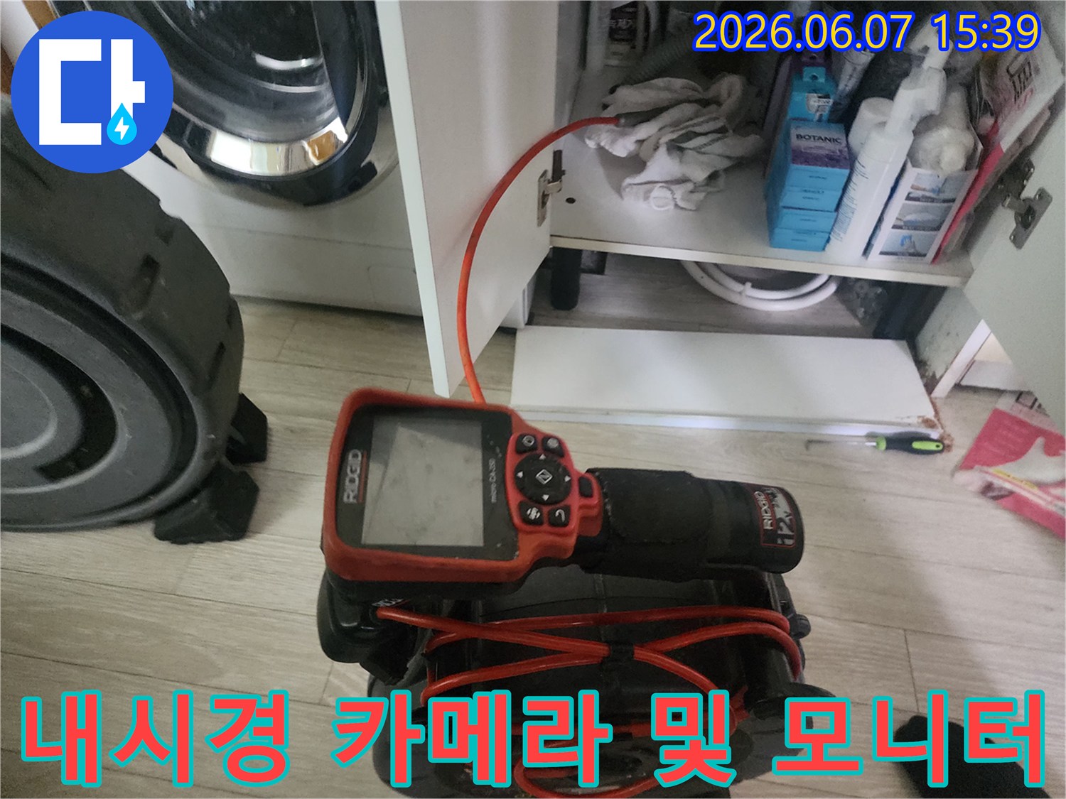 싱크대 하부장 아래에서-작업 중인 내시경 장비와 전선