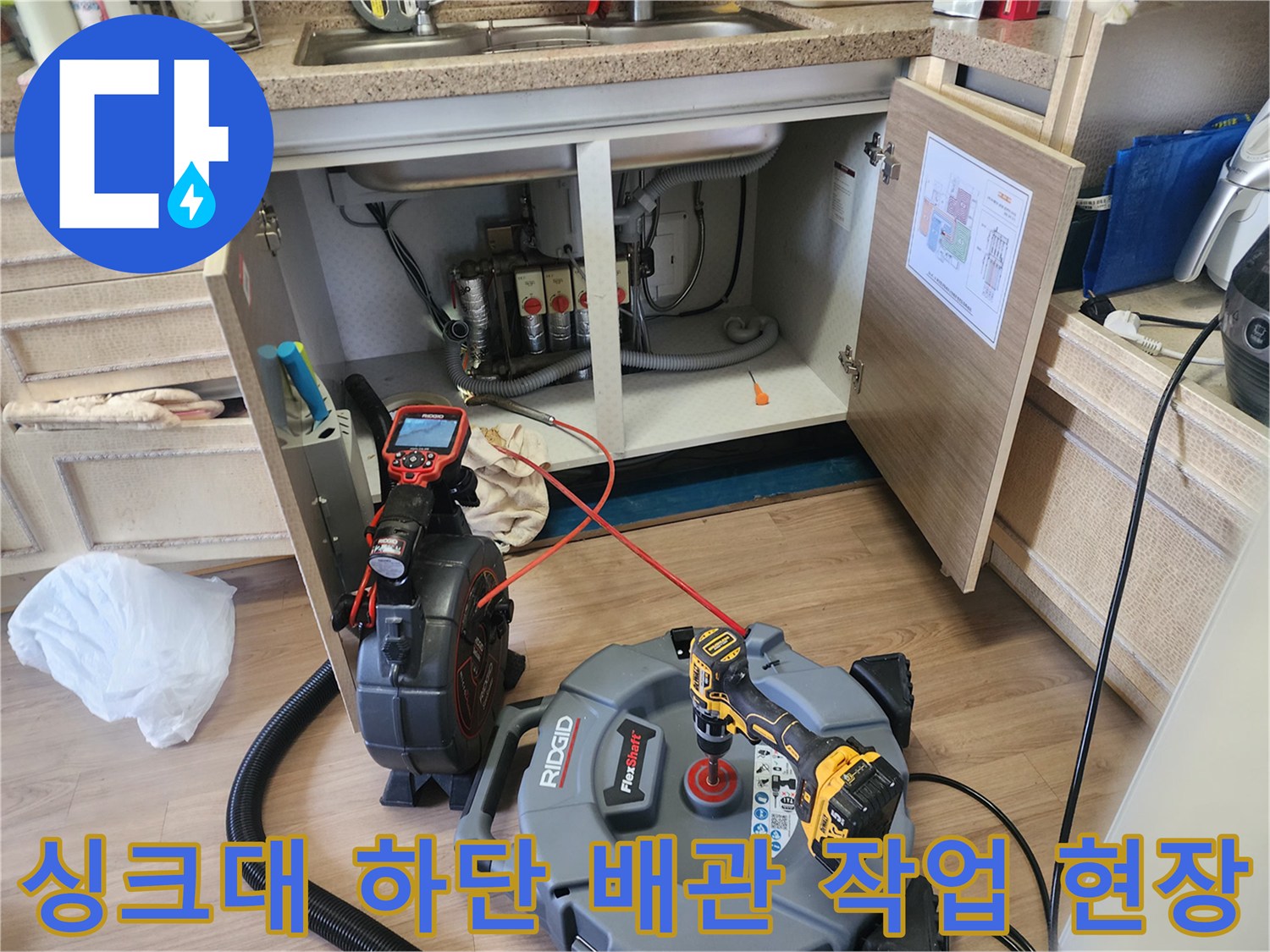 싱크대 아래 배관 청소를 위해 배치된 석션기와 내시경 카메라 장비