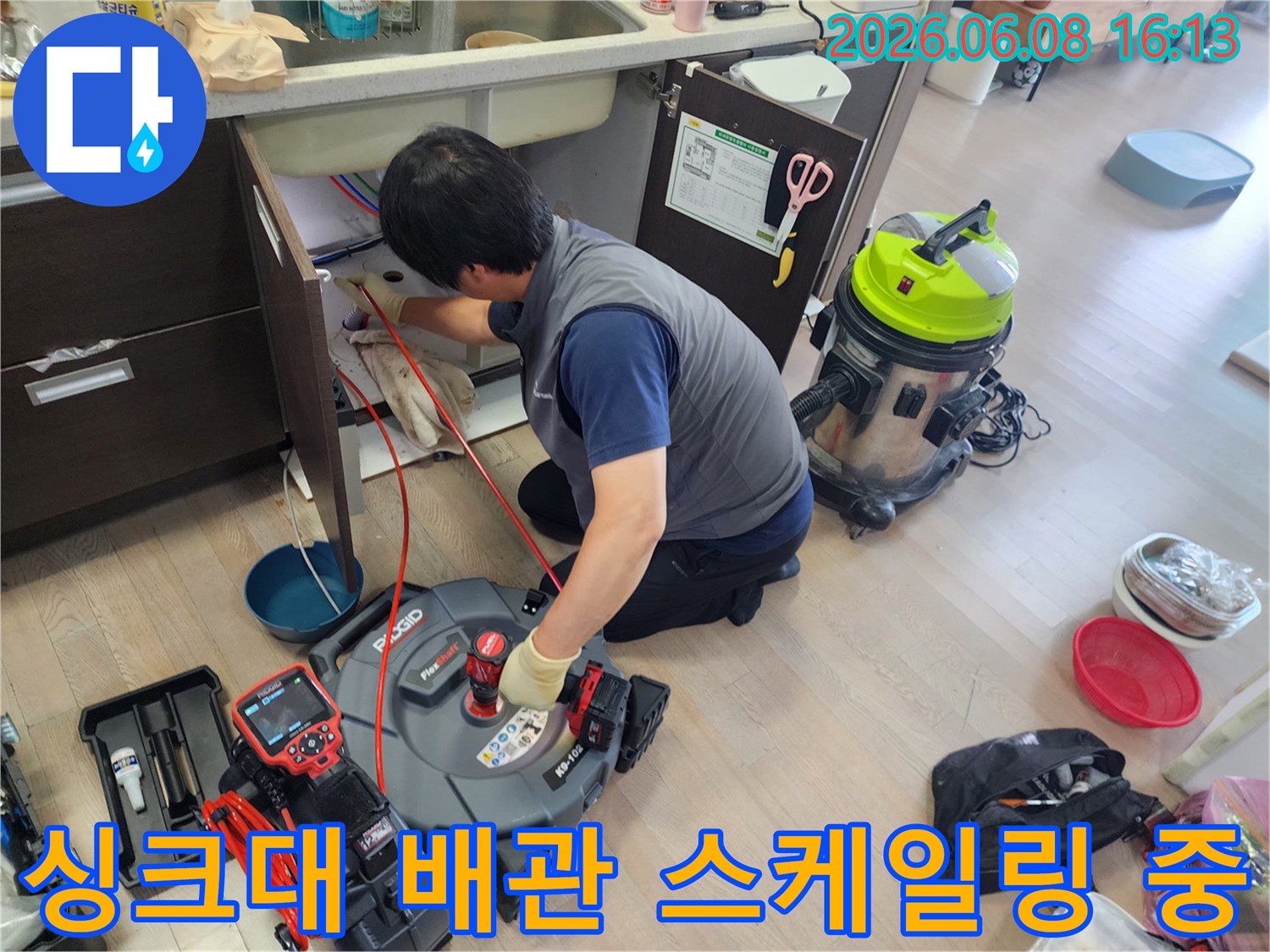 싱크대 하부장 아래에서-전문 장비로-배관 스케일링을 진행하는 모습입니다.