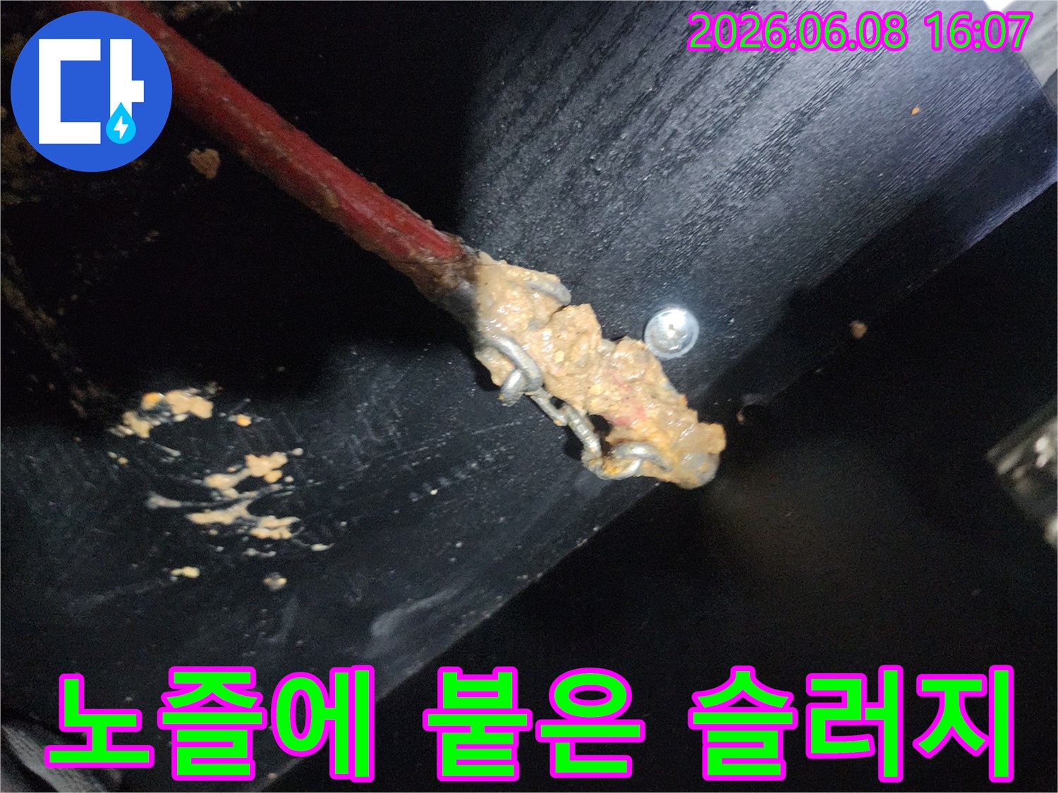 배관 스케일링 작업 중-노즐 끝에 가득 묻어나온 붉은색 기름 슬러지 상태