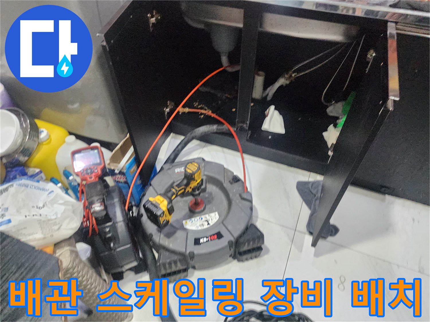 싱크대 하부 배관 부근에 설치된 내시경 모니터와 작업 도구들