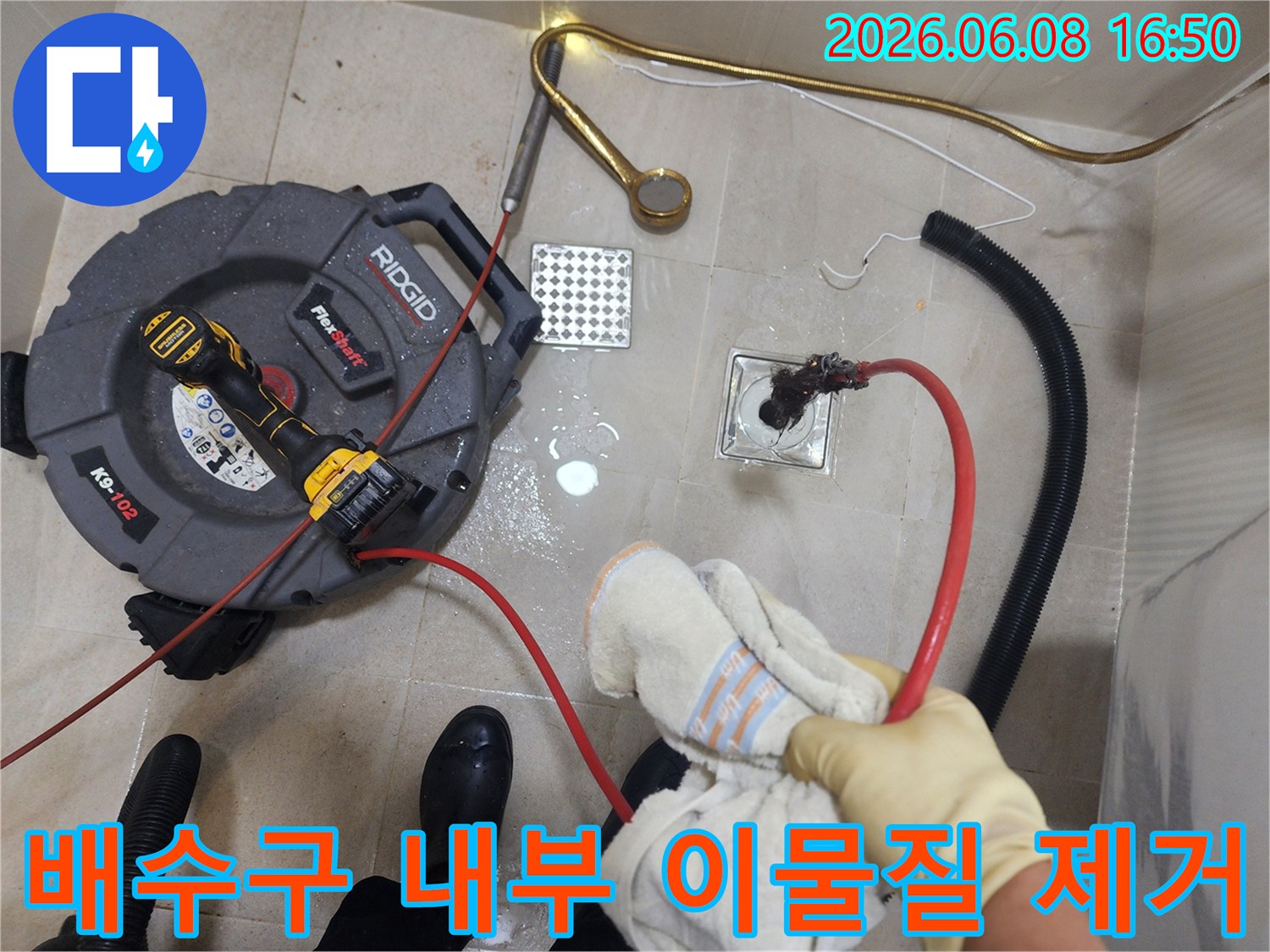 배수구 입구 근처에서 진행되는 배관 스케일링 장비 운용 모습