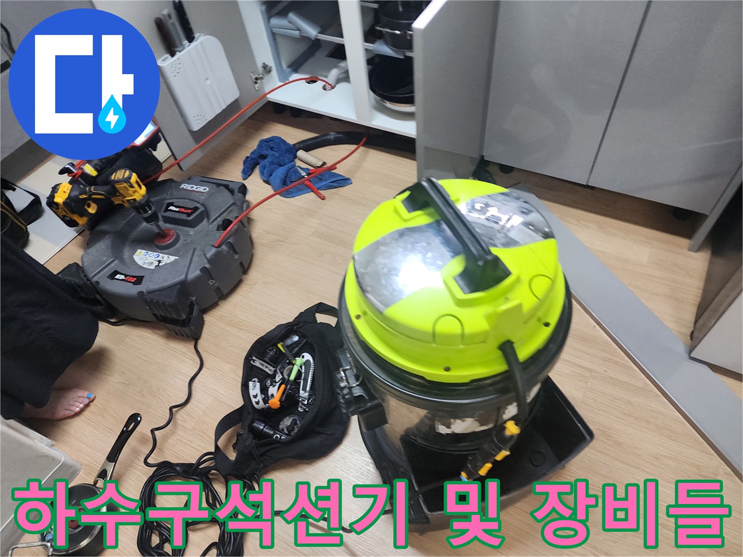 배수관 내부의 오염물을 빨아들이는 산업용 집진기와 작업 도구 세트입니다.