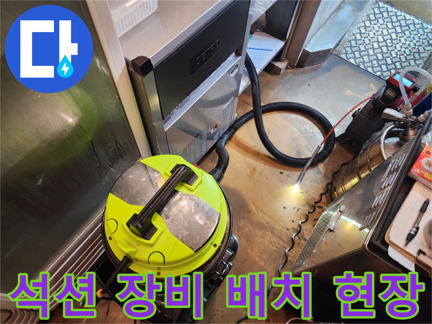 바닥에 설치된 노란색 석션기와 연결된 검은 호스
