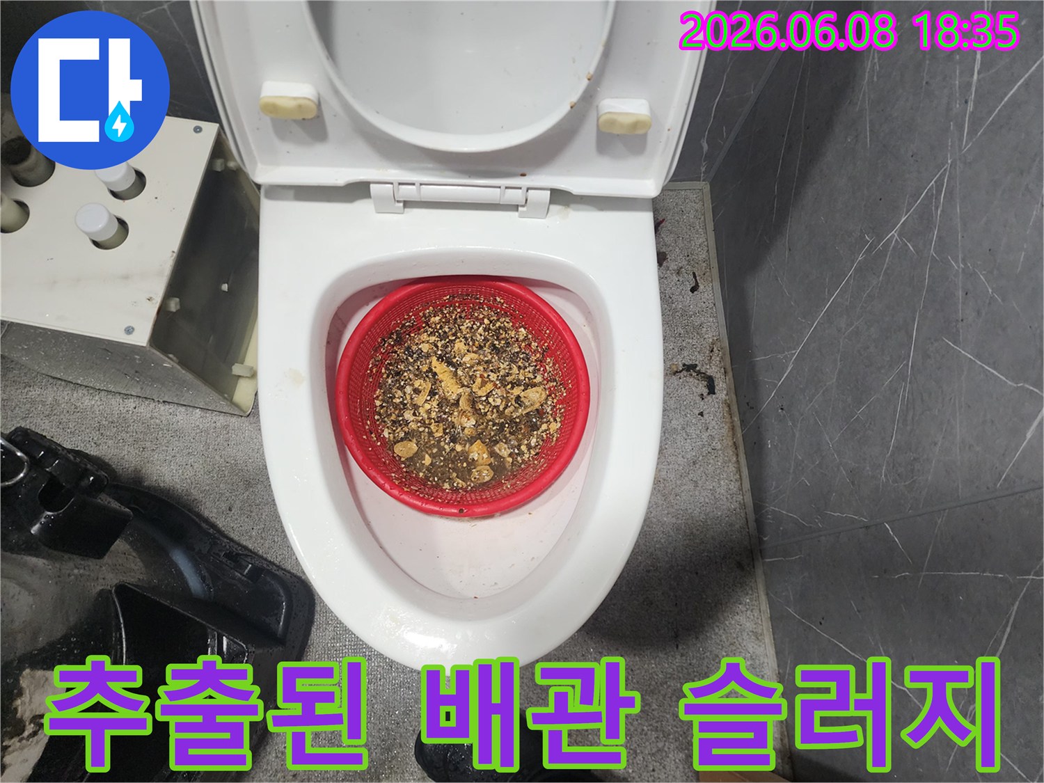 빨간색 거름망에 쌓여 있는 배관 스케일링 작업 후의 오염 물질