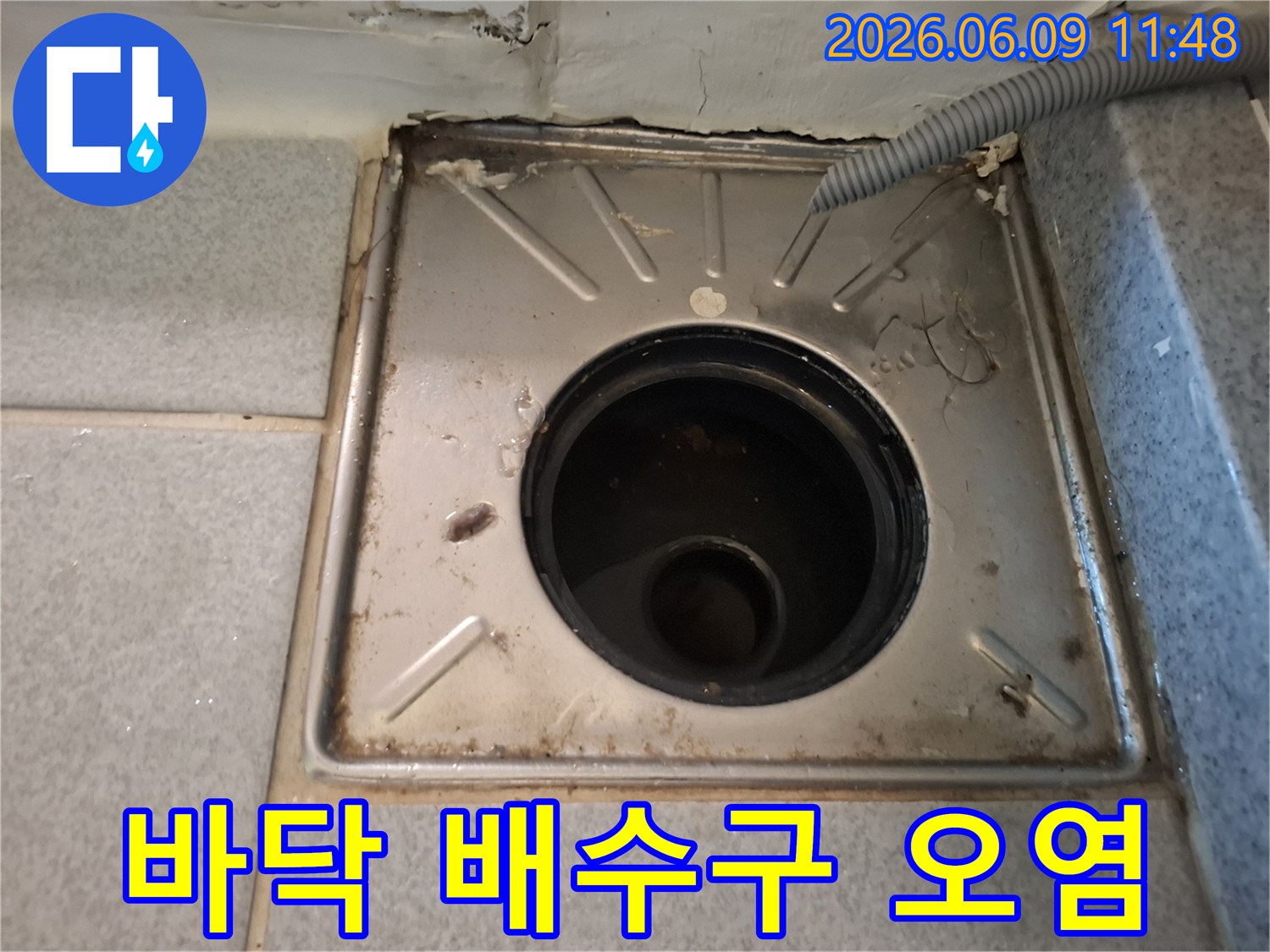 오염된-욕실-배수구와-손상된-주변-타일-틈새를-보여주는-사진입니다.