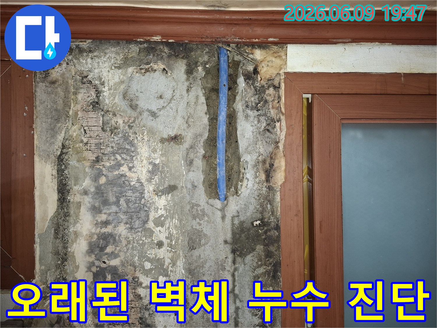 오래된-건물의-벽면-누수로-인한-벽지-손상과-내부-배관이-노출된-현장-사진