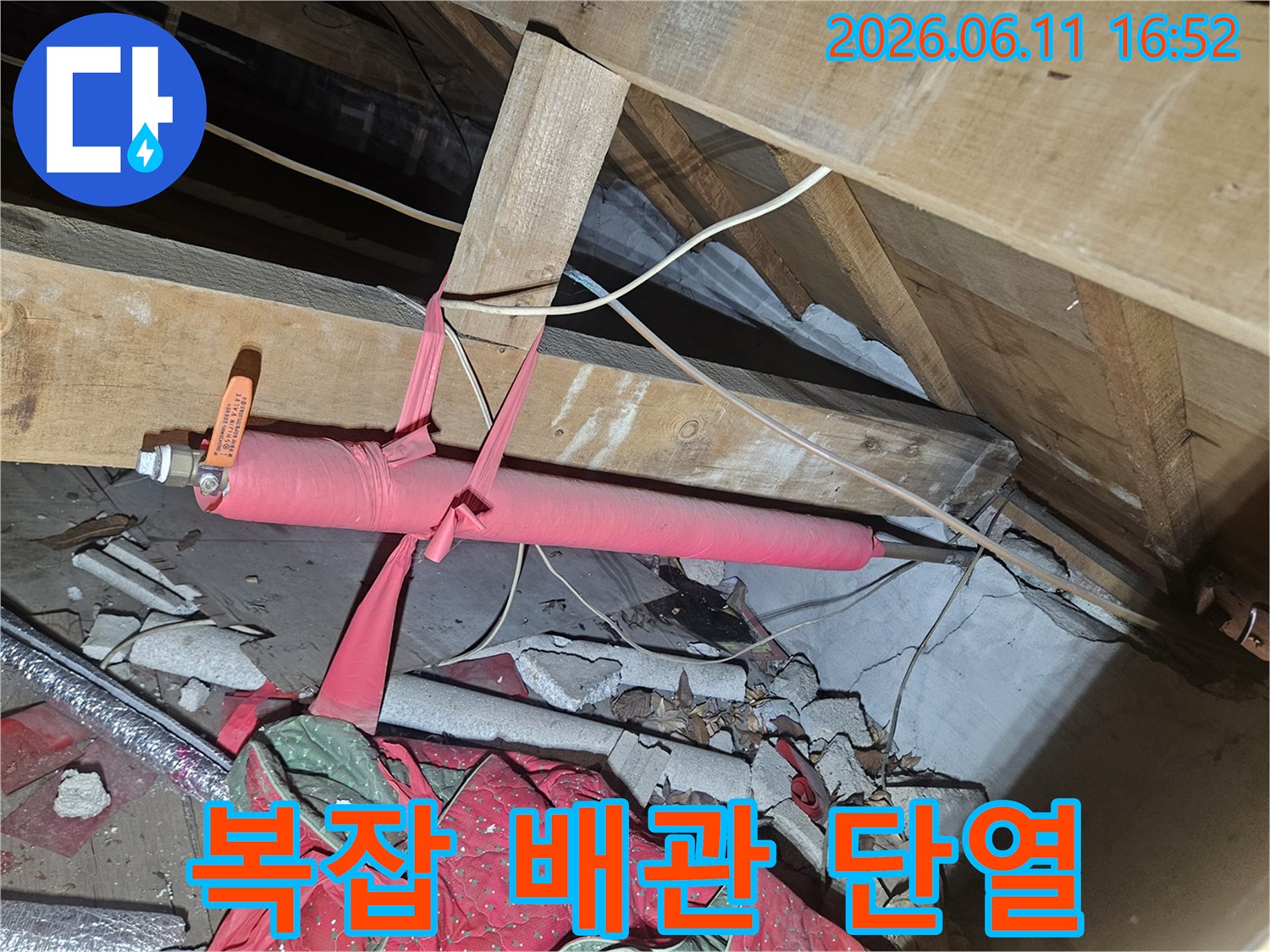 복잡한 천장 구조물 사이로-노출된 배관에 새로운 보온재를 감아-안전하고 효율적인 단열을 완성하는-전문가의 작업 현장입니다.