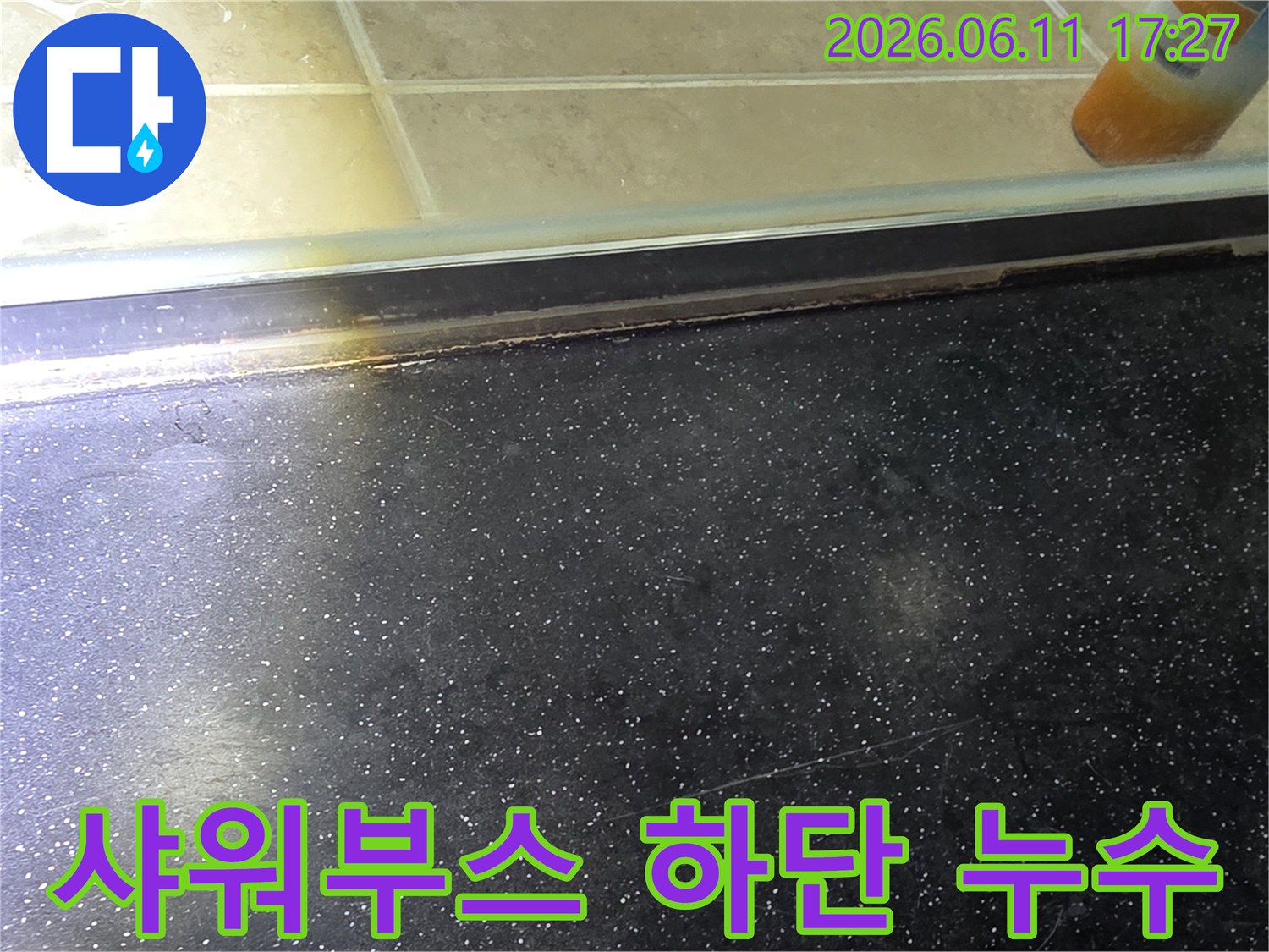 욕실 샤워부스 하단-타일 경계면에서 발견된 누수 흔적을 보여주는 사진