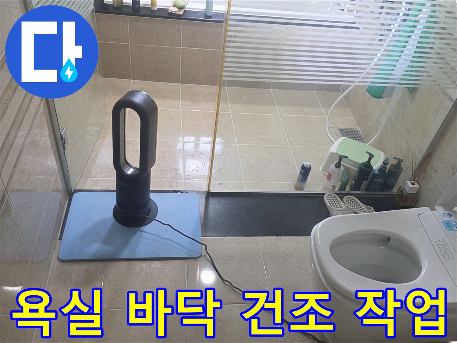 화장실 변기 옆에 설치된 공기 순환 장치와 타일 바닥