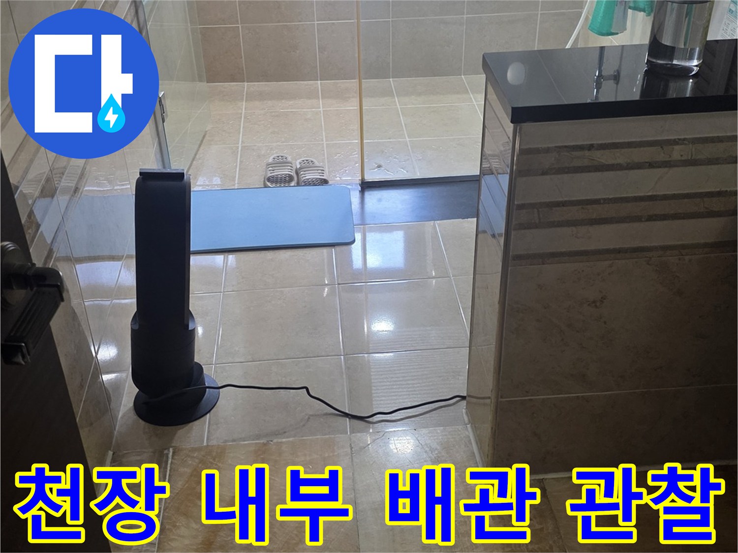 화장실 천장 안쪽의 타일 벽면과 배관 구조물 촬영
