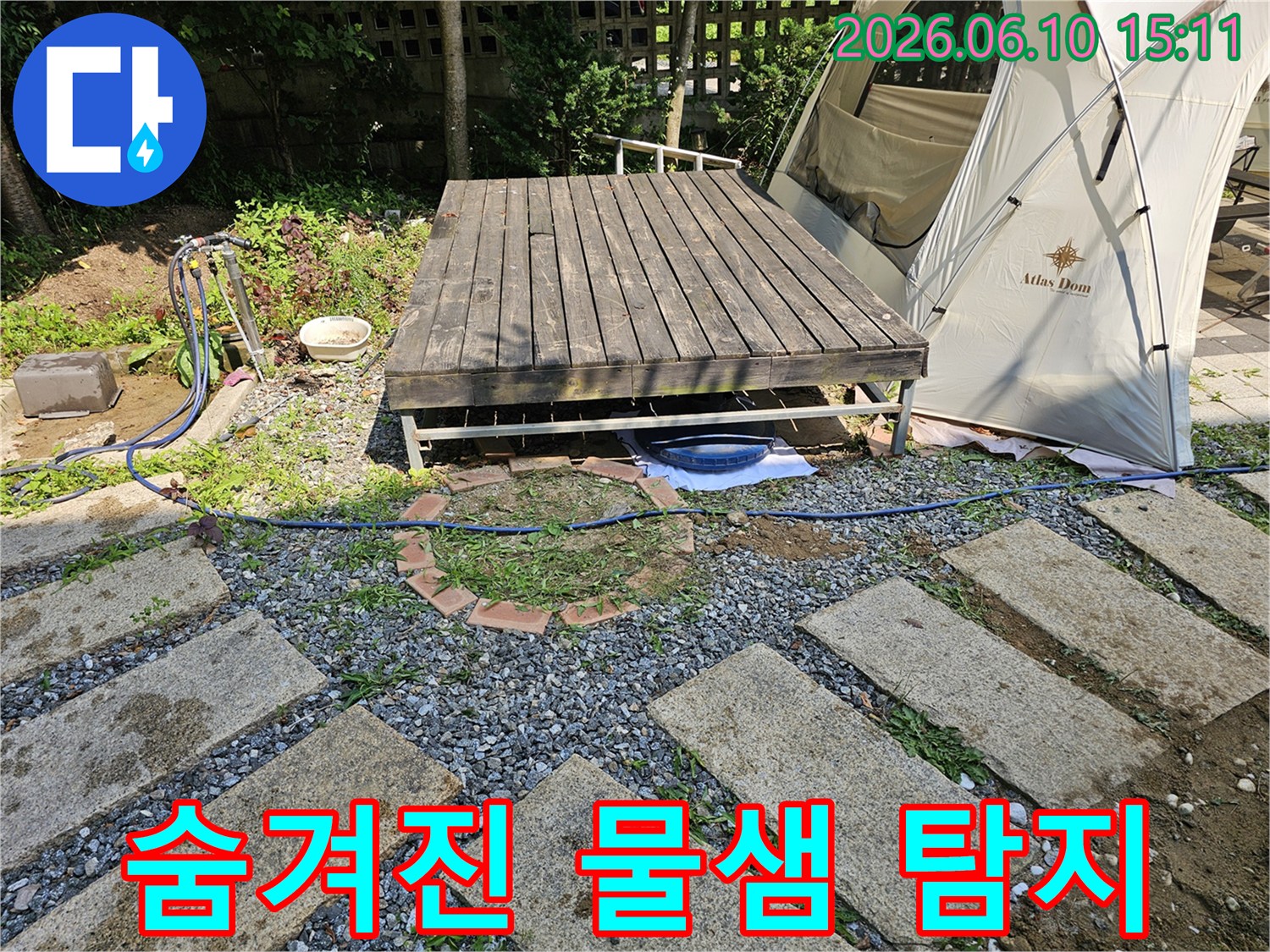 야외 데크 아래-숨겨진 물샘을 찾아내기 위해-현장을 면밀히 조사하는 모습