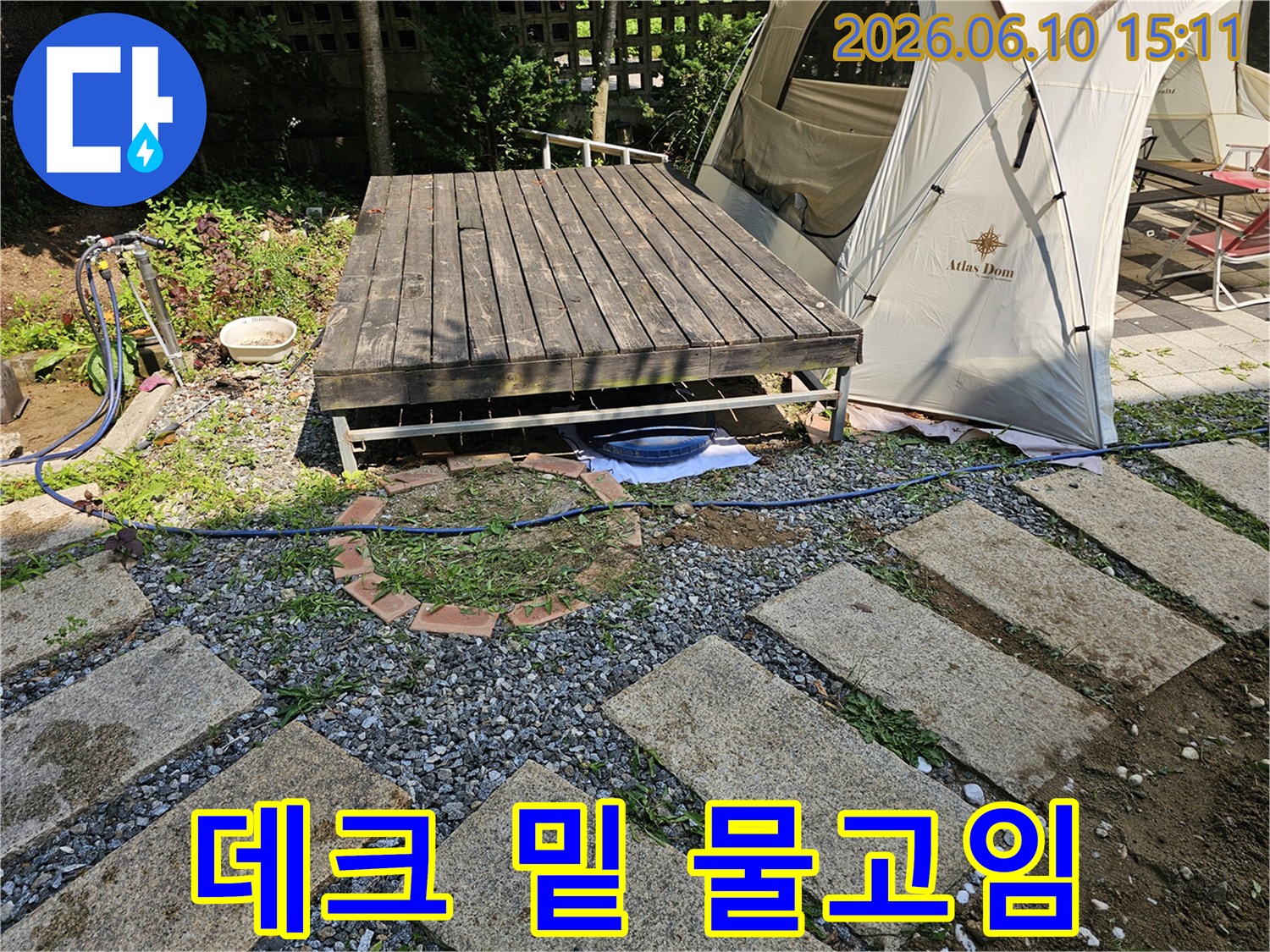 이 이미지는-양평 주택의-데크 아래에서-물이 고여있는-누수 현장에-임시 물받이를 설치한-초동 조치-모습을 보여줍니다.