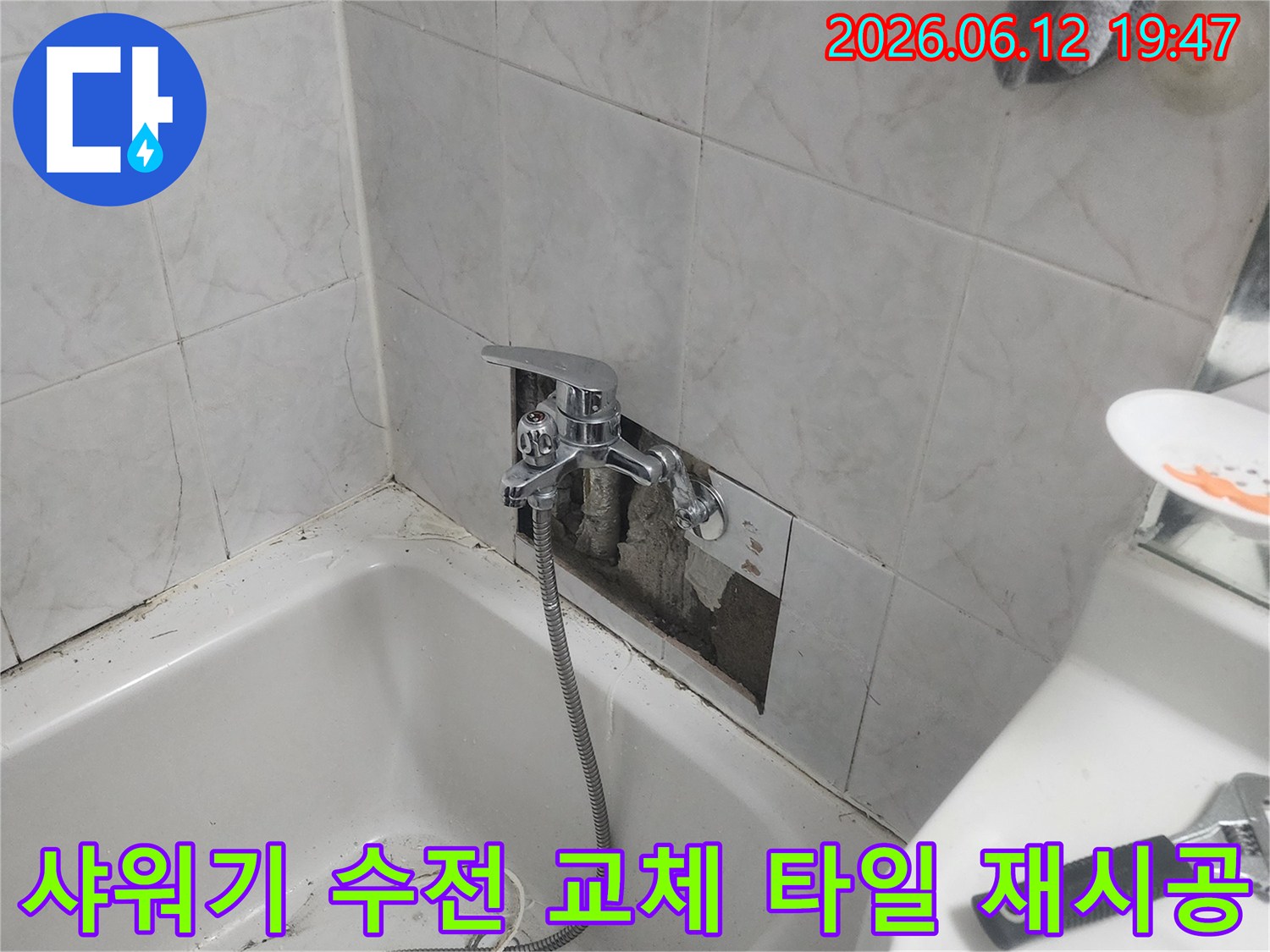 욕실 벽면의 타일이 제거된-상태에서-새로운 샤워기 수전이-설치되고-타일 재시공이-진행되는-모습을-담은-사진입니다.