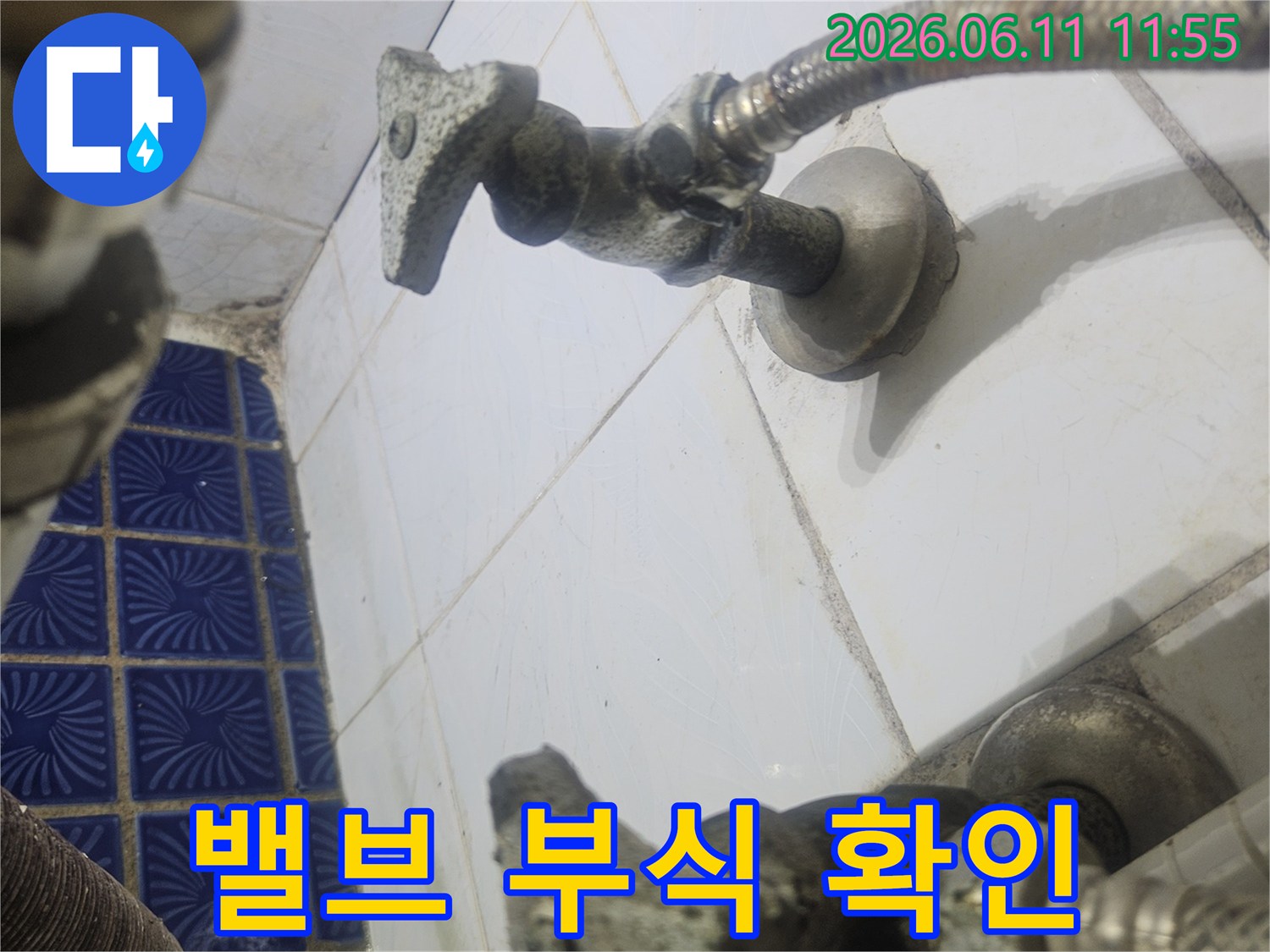 급수관의-앵글밸브가-타일에 고정된 모습과-연결 부위의-상태를 보여줍니다.