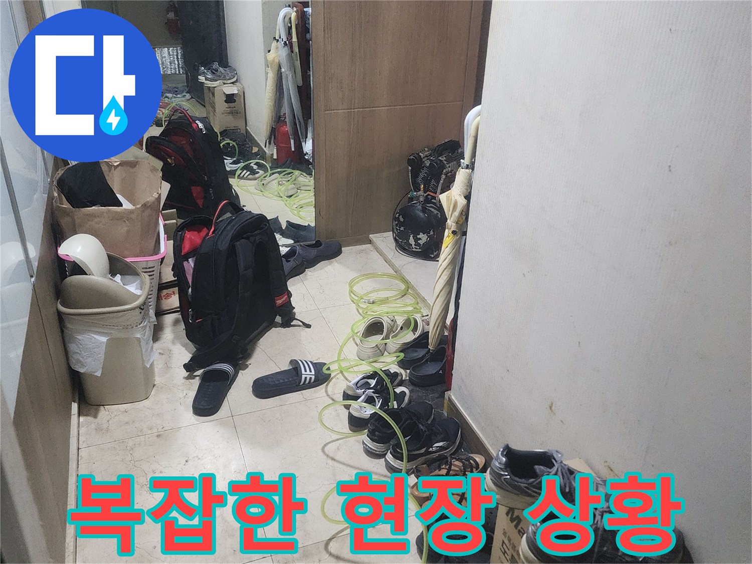 누수 탐지 작업을 위해-현관에 장비를-배치하고 있는-모습을 보여주는-사진입니다.
