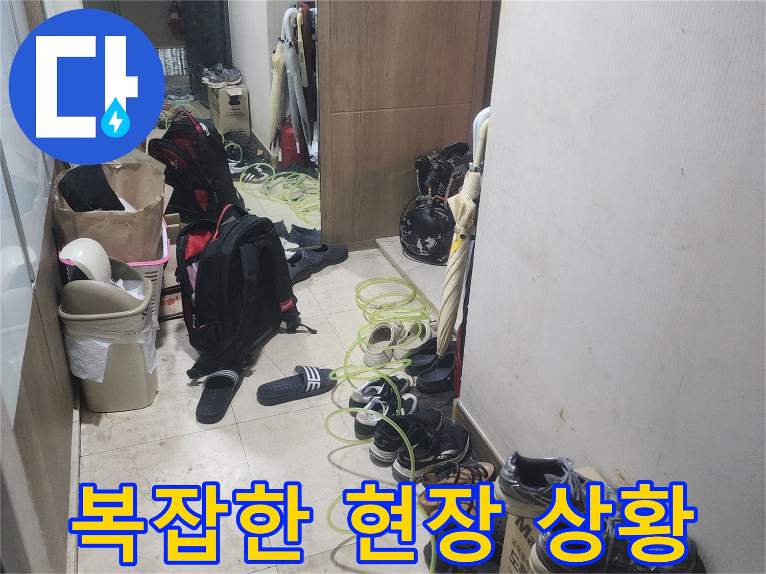 누수 탐지 작업을 위해-현관에 장비를-배치하고 있는-모습을 보여주는-사진입니다.