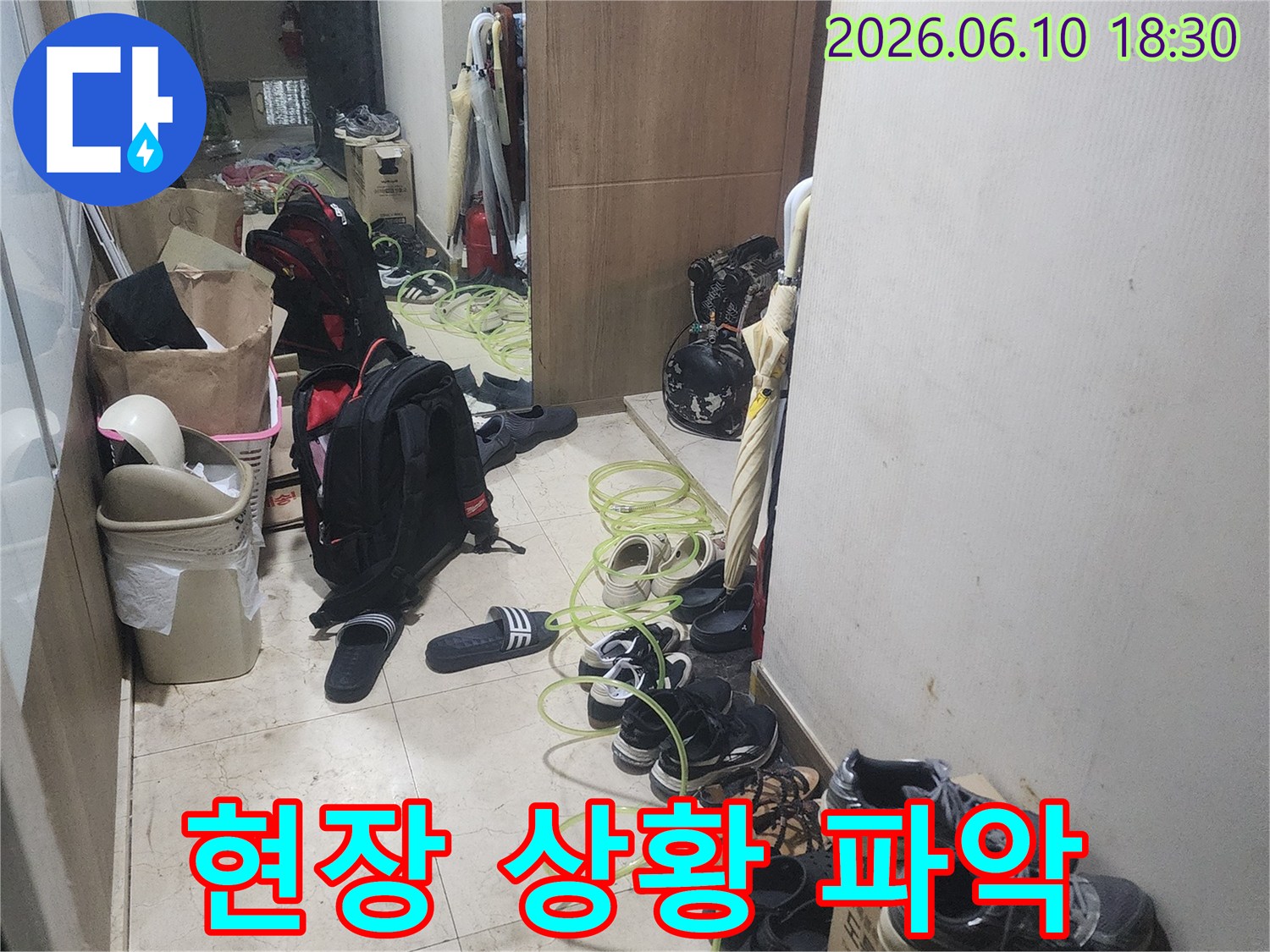 누수 탐지 작업을 위해-현관에 장비를-배치하고 있는-모습을 보여줍니다.