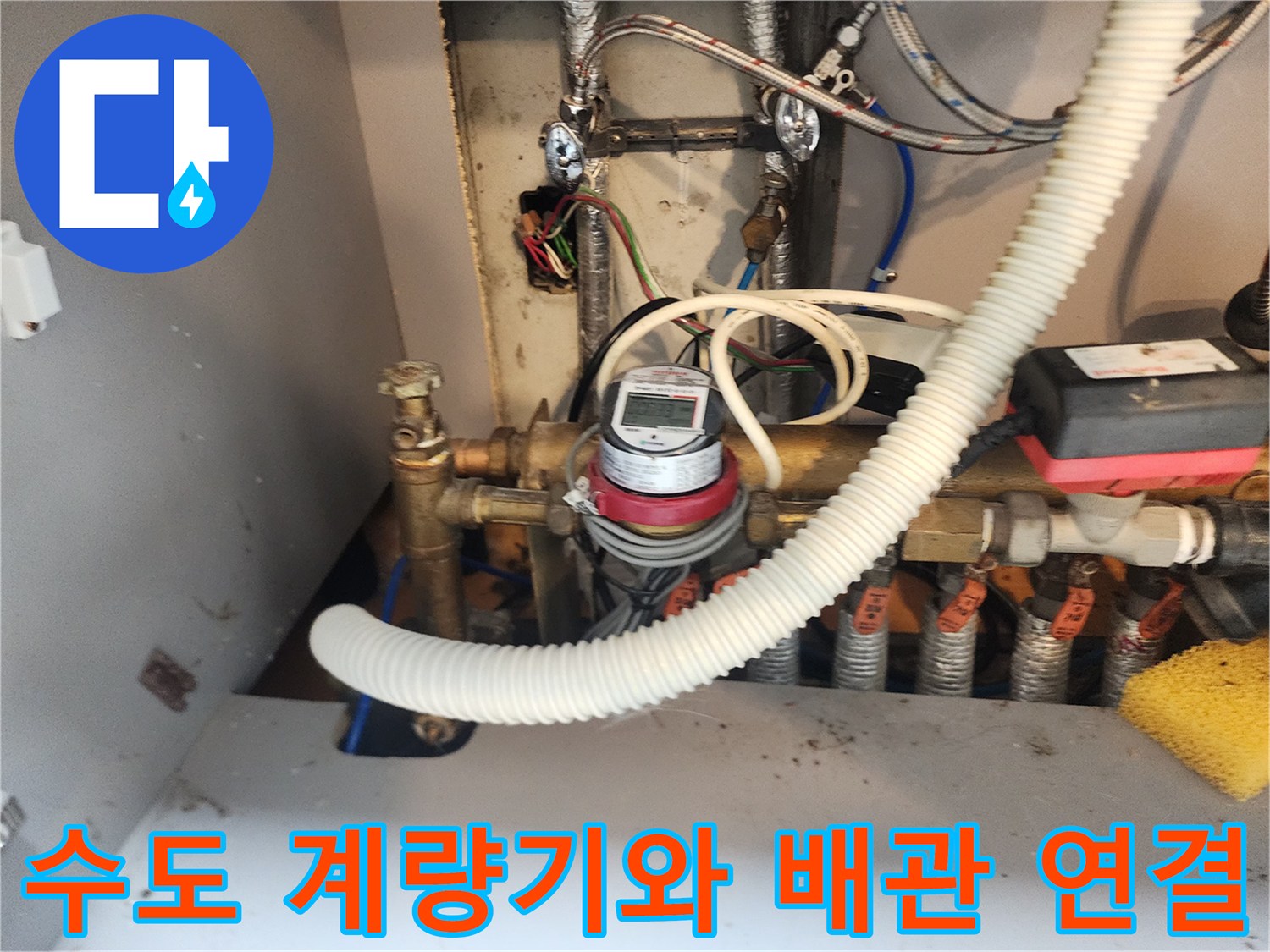 금속 배관과 유량계가 설치된 주방 하부 구조 촬영