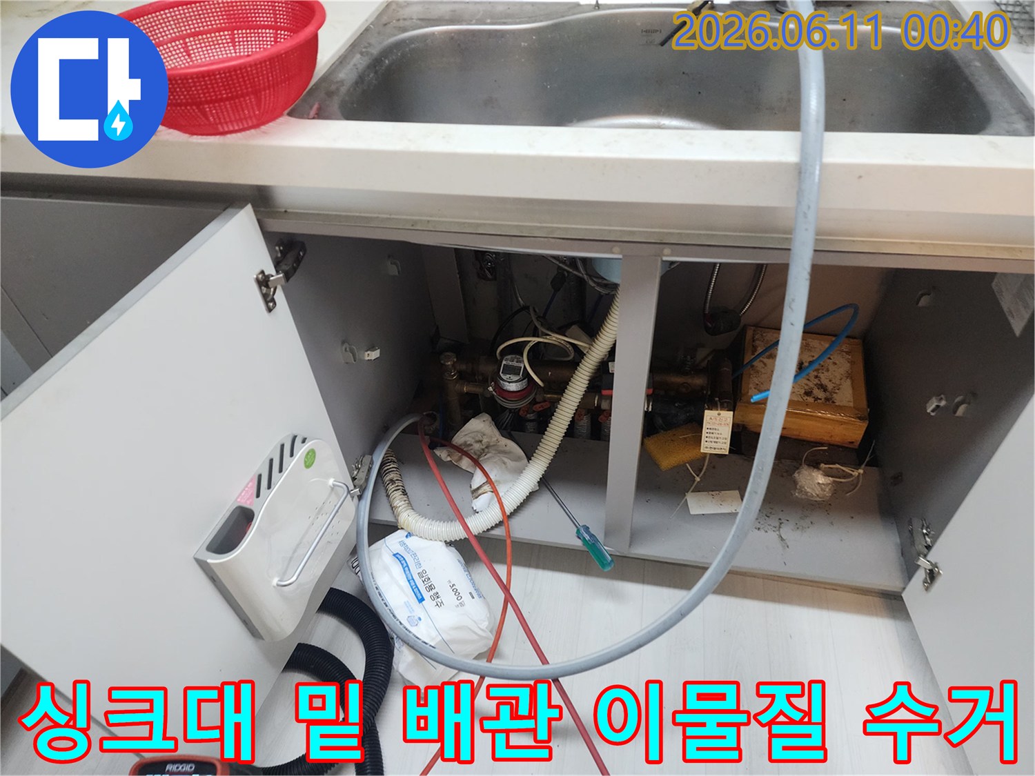 싱크대 하부장 내부의 복잡한 배관과 수거된 슬러지 모습입니다.