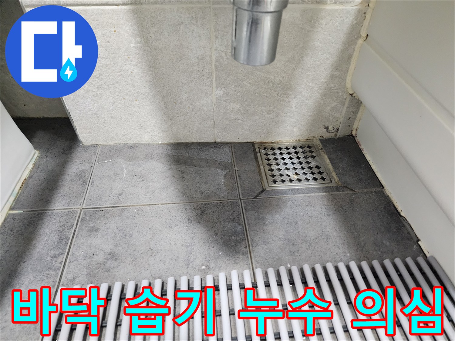 이 사진은-욕실 바닥 타일의-전반적인-습기와-어두워진-색상을-보여주며-지속적인-누수로-인한-습기-문제를-암시합니다